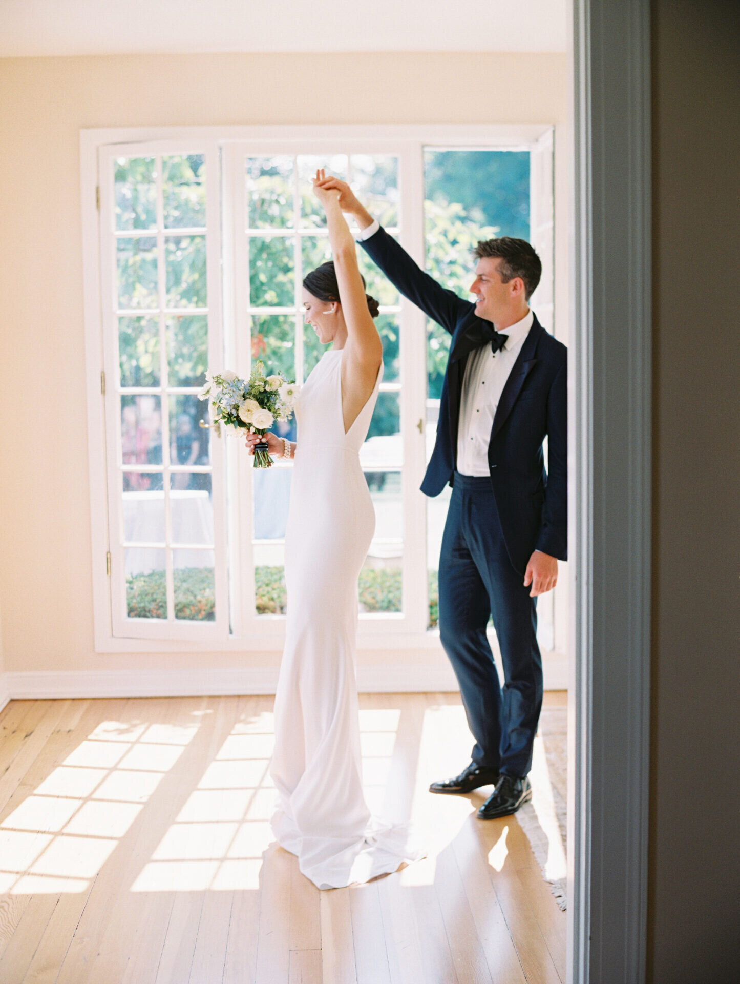 groom spinning his bride while dancing in a room full of windows in seattle