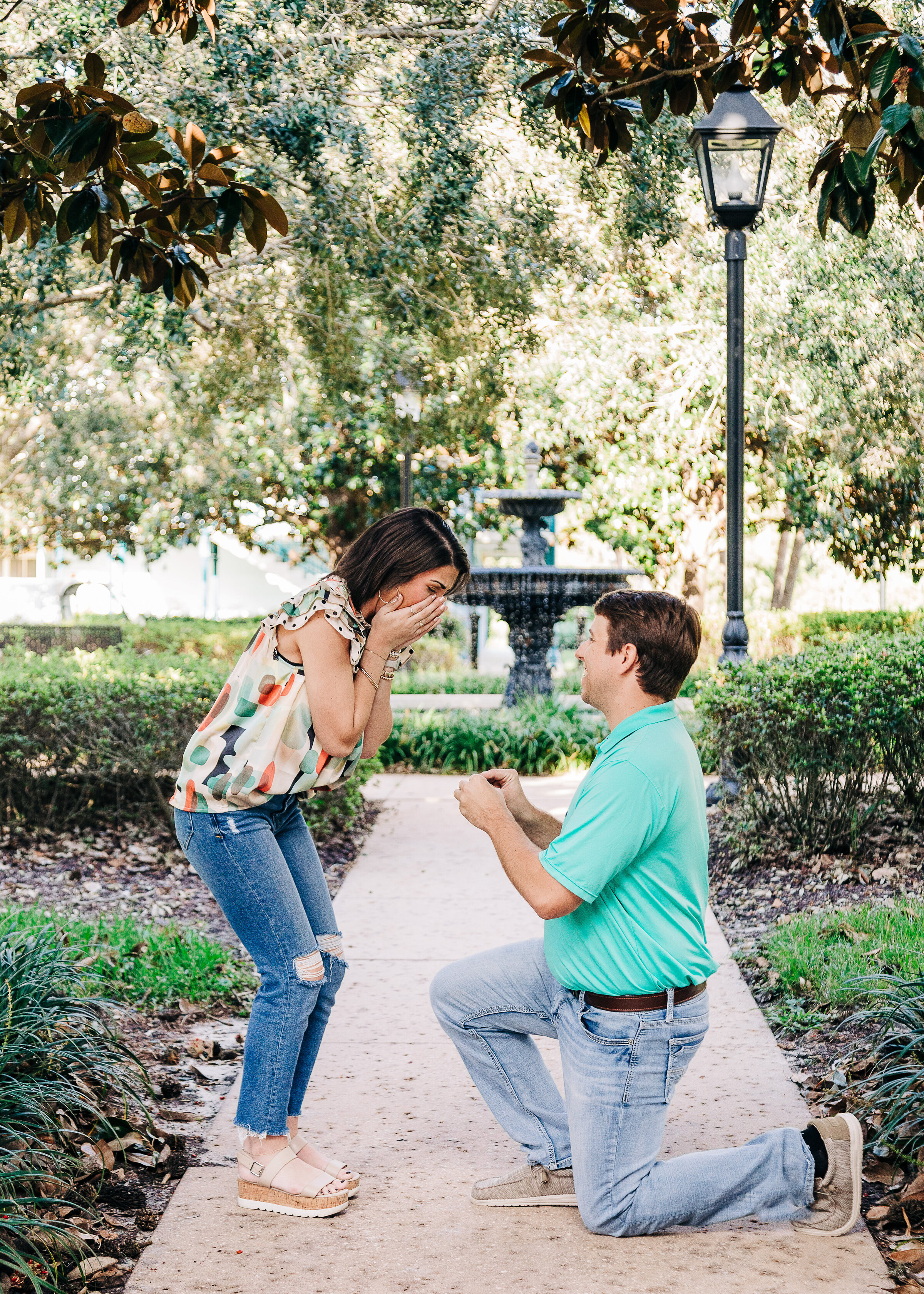 Surprise proposal ay Disney's French Quarter, man on one knee, woman excited and emotional