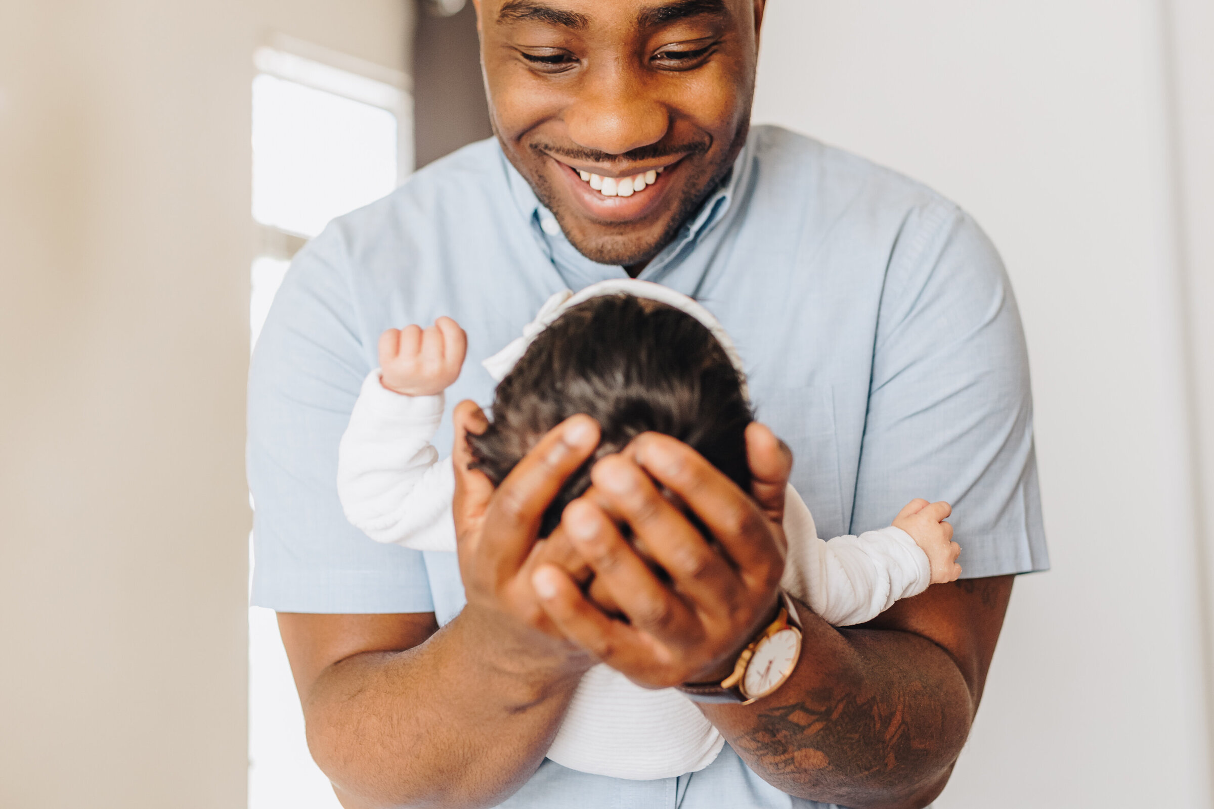 Black Dad Smiles at Newborn Baby