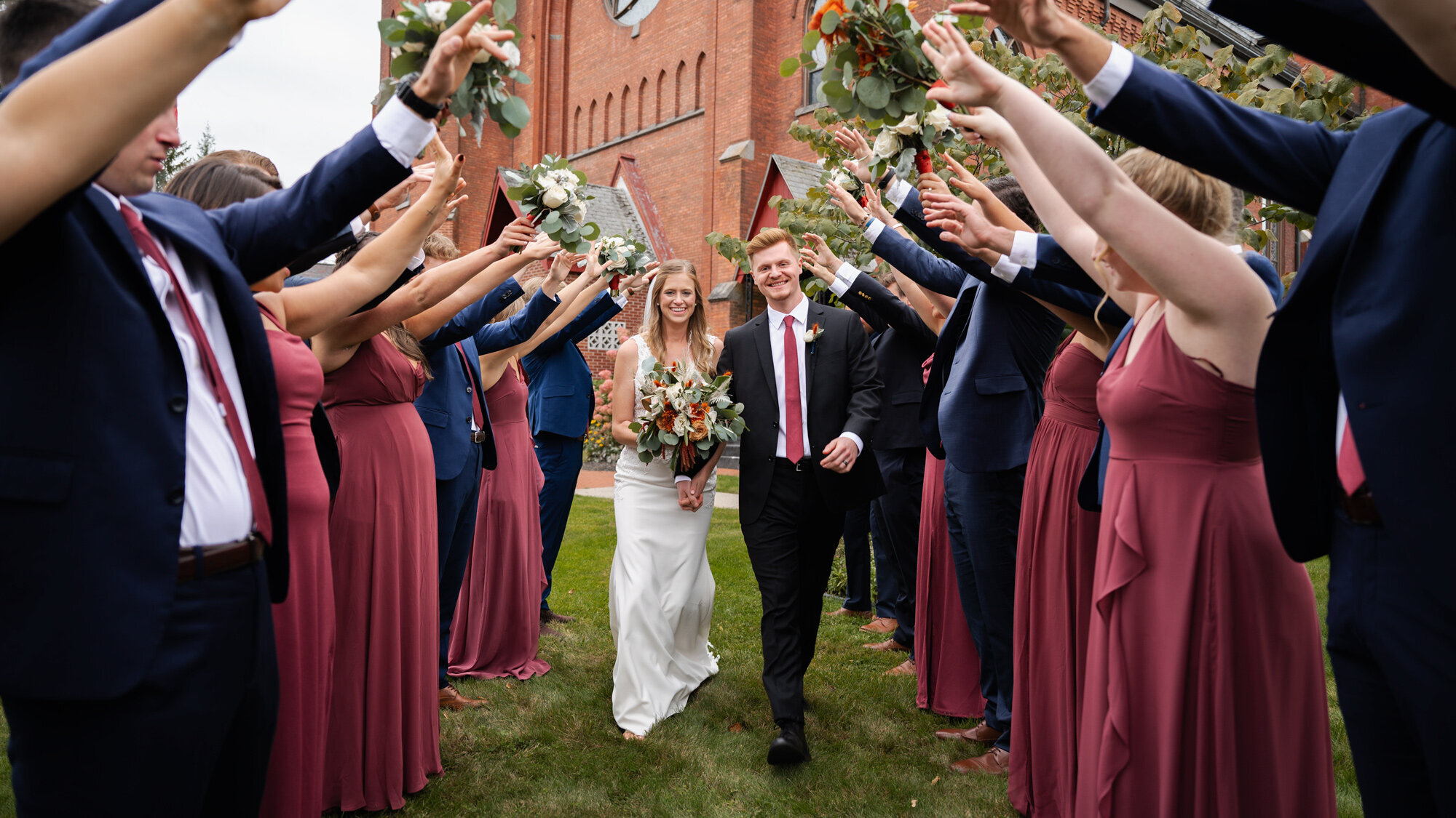 The bride and groom walking through a tunnel of their bridal party after their wedding in Ballston Spa, NY.