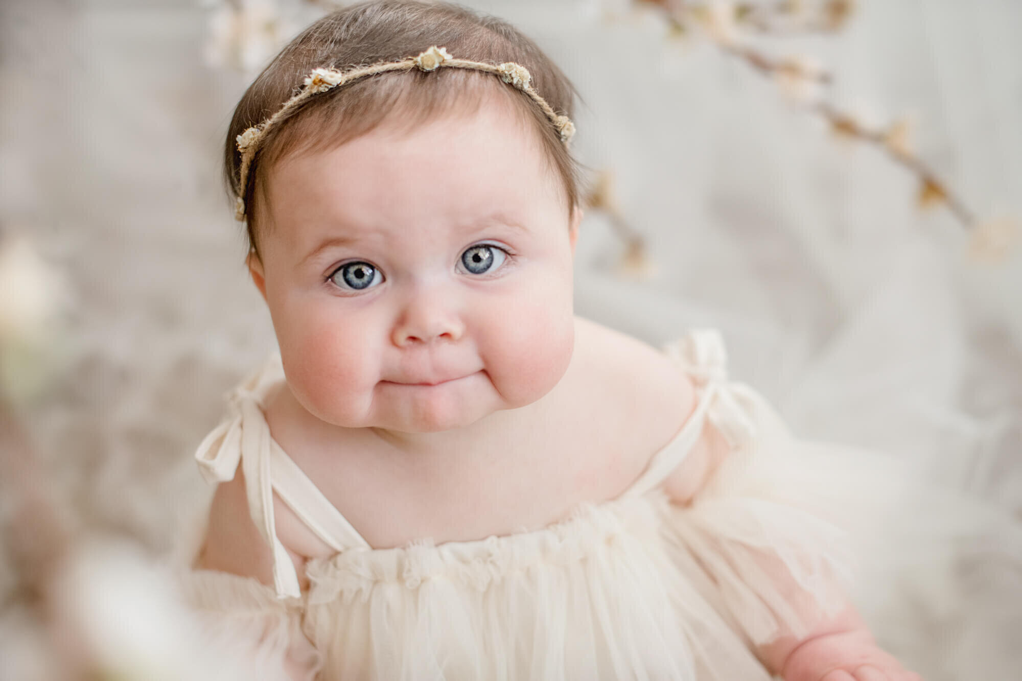 Baby girl with big blue eyes and tulle dress