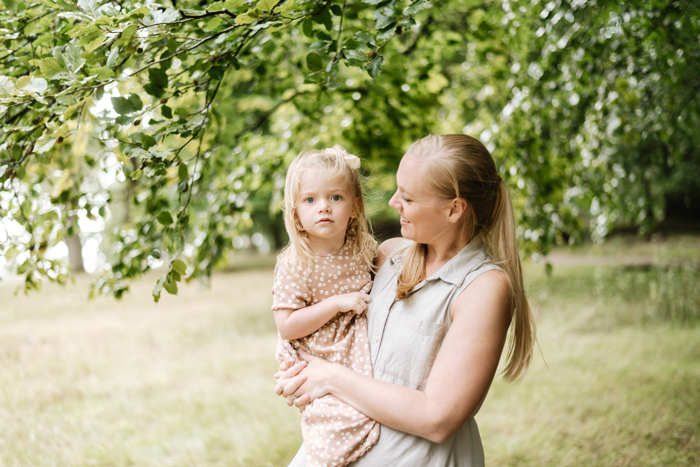 Mother holding her daughter in a park in Billingshurst on a family photoshoot