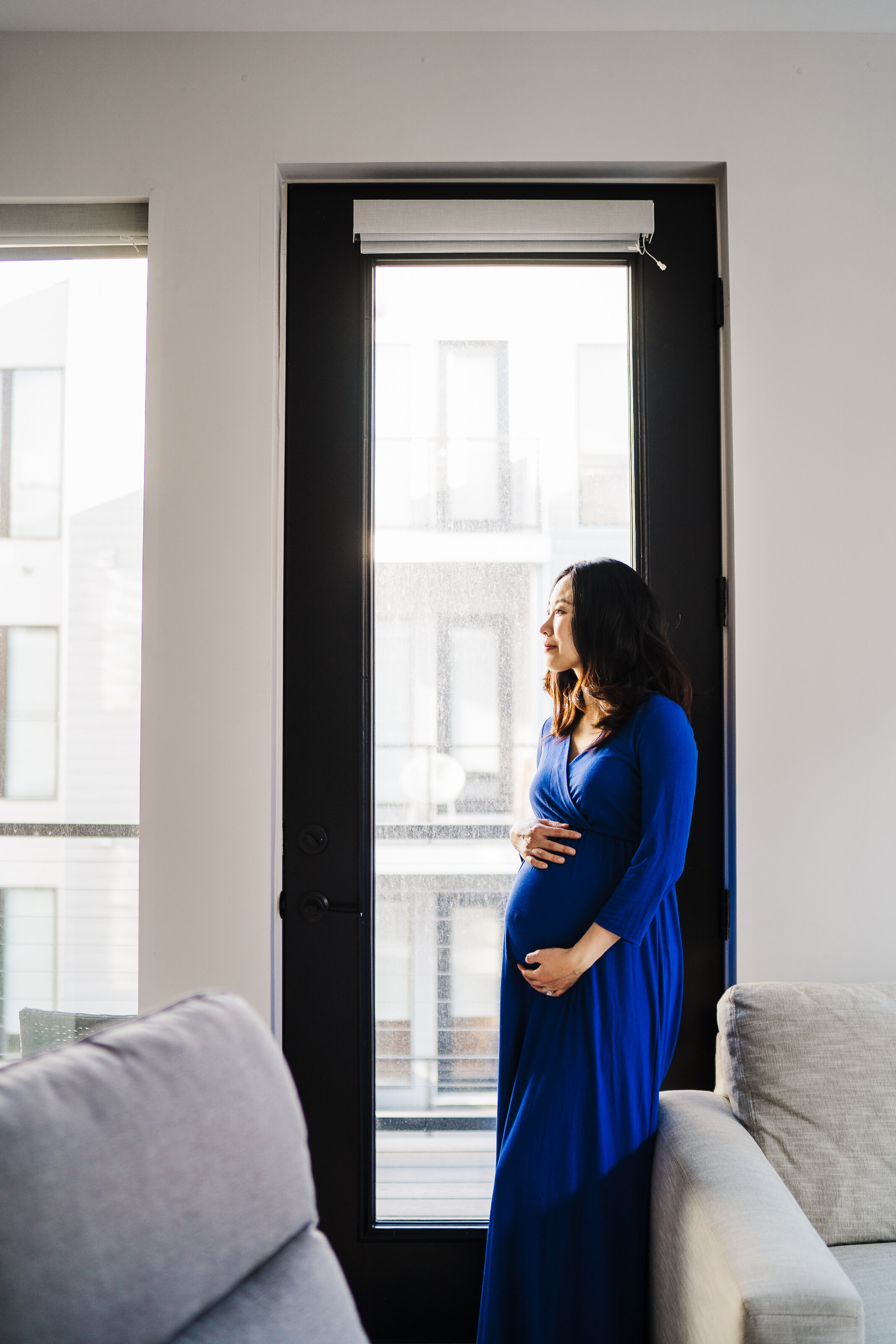pregnant woman leans against door frame in boston apartment