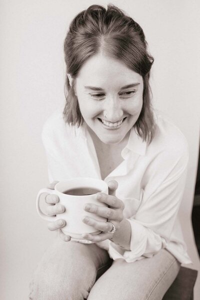 fallback shared on Invalid Date | a black and white photo of lorin husa sitting with tea and smiling off camera