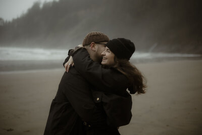 fallback shared on Invalid Date | a couple embraces while laughing on the moody oregon coast