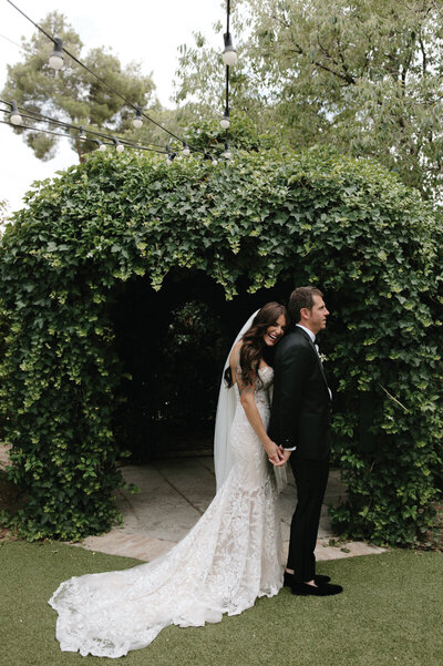 bride-smiling-holding-grooms-hand-in-spain-garden
