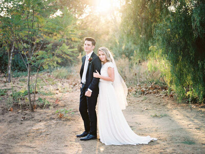 Southern California wedding photographer capturing bride holding her groom beachside in San Diego