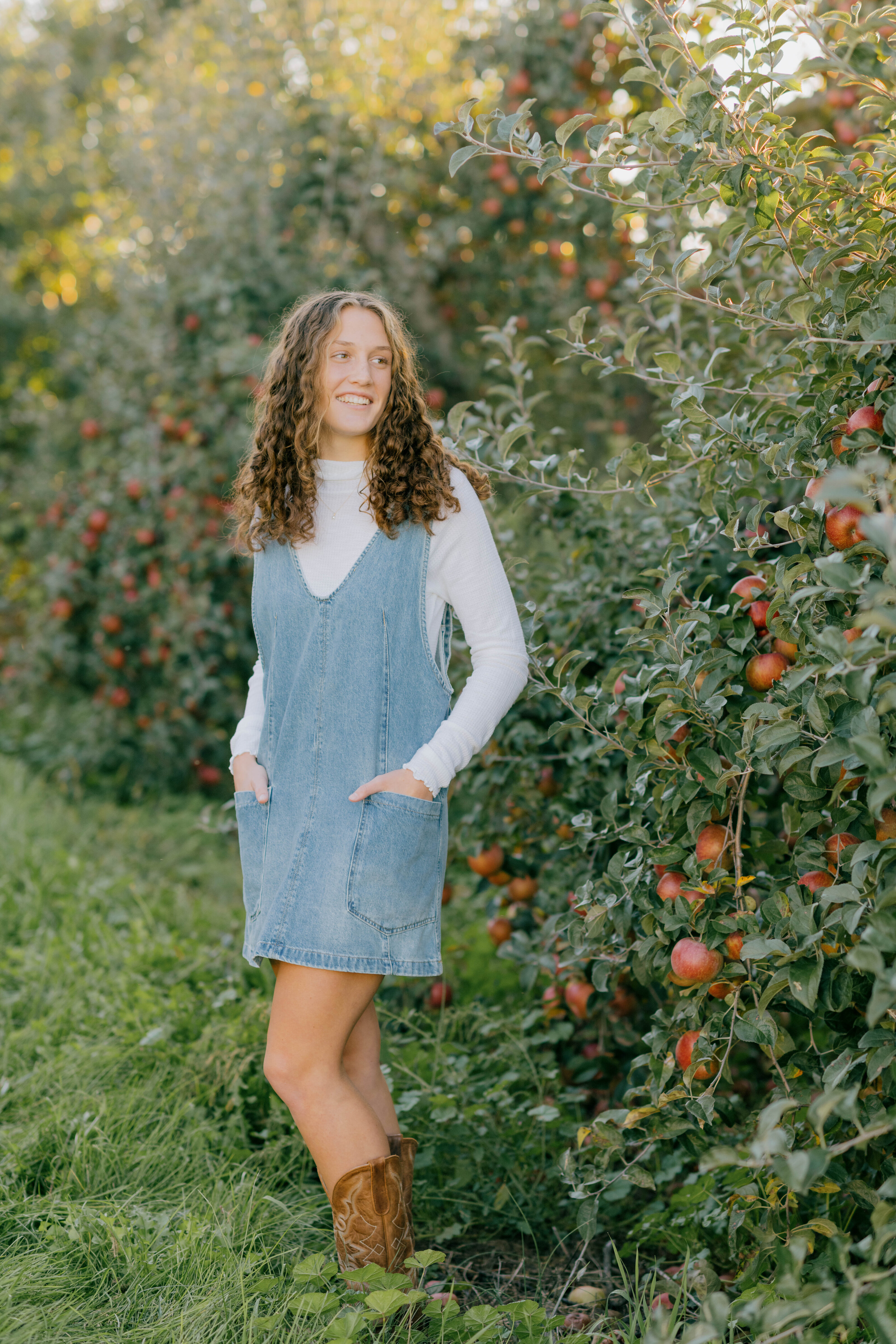 Sadie smiles as she stands among the apple trees in a Timberville orchard.