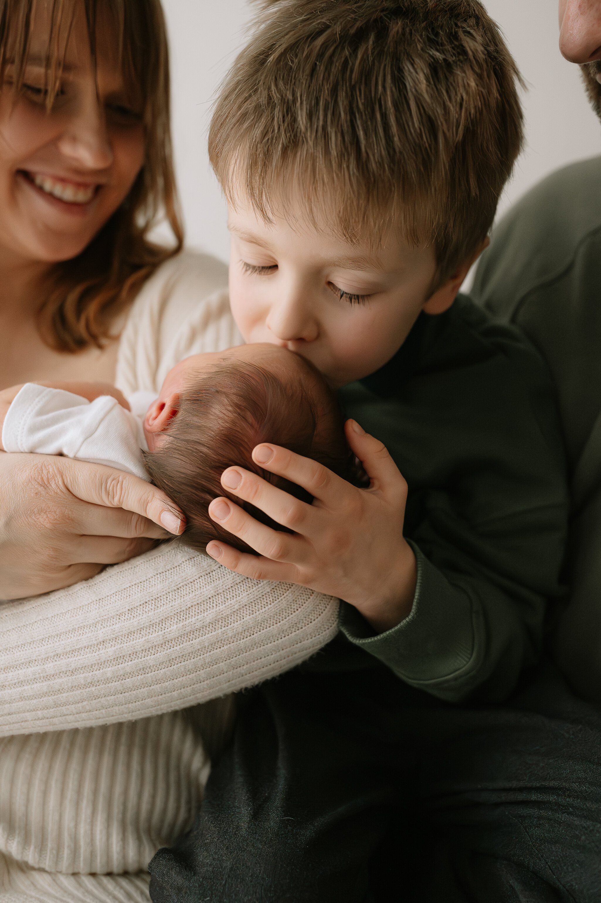 baby girl and big brother beind held by Mum at York newborn, baby and family photographer in York