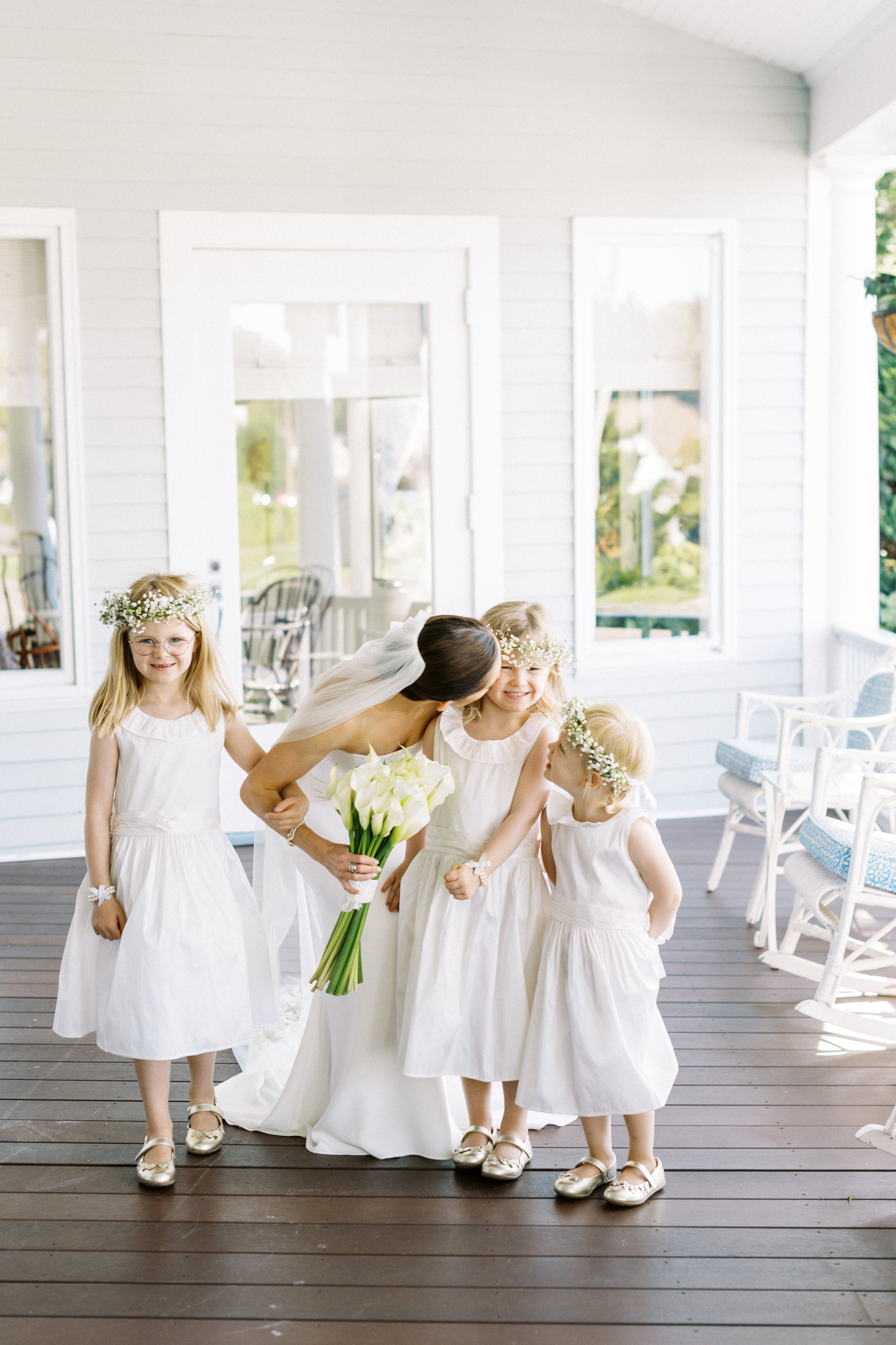 bride kisses flower girl ont he cheek at Wianno Country Club on Cape Cod