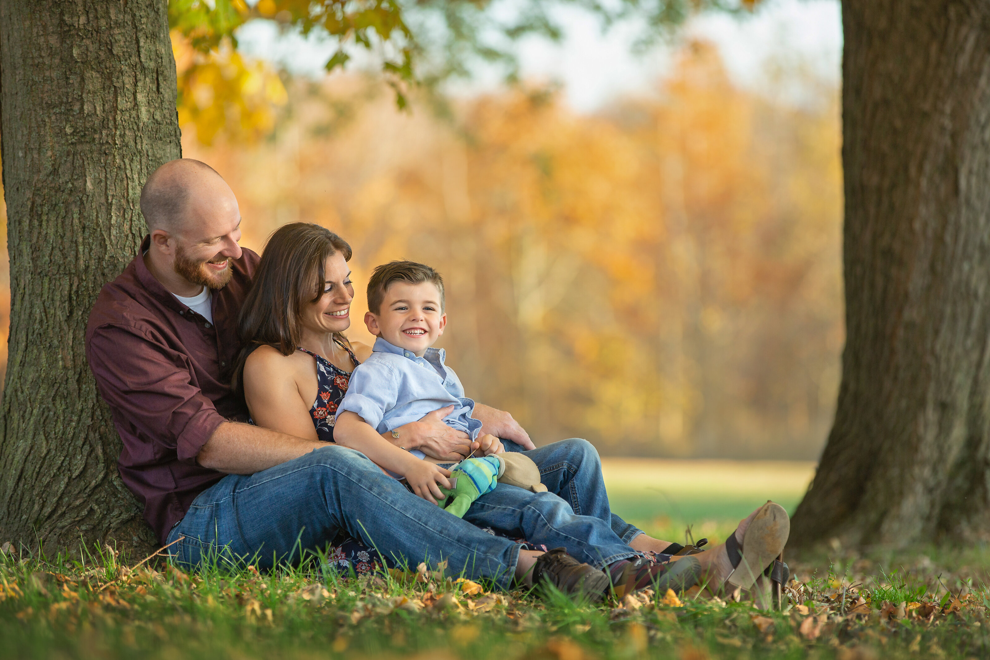 Family cuddling for photos during  New Jersey Family Portrait session at park