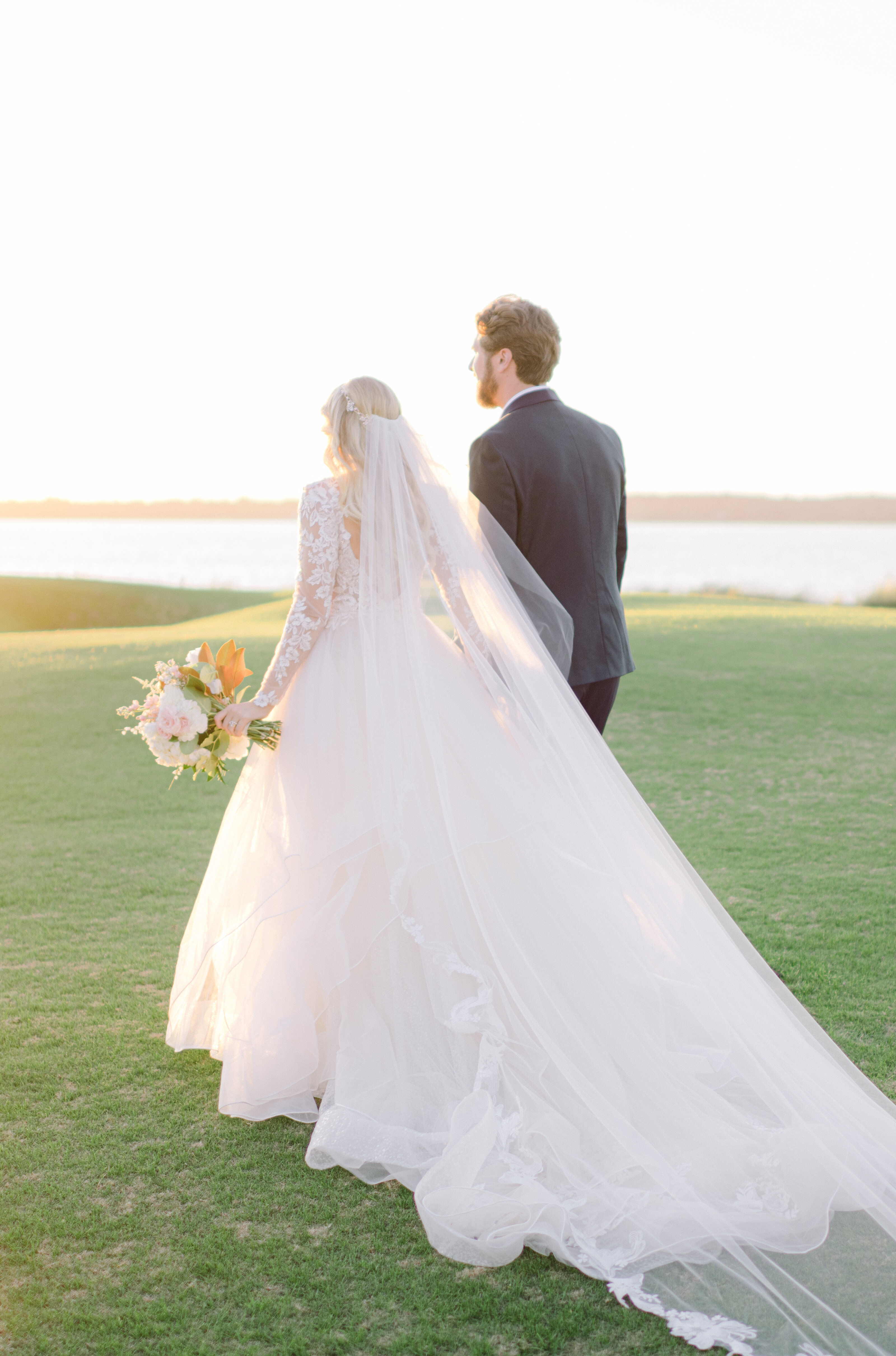 A bride and groom walk hand in hand at sunset on the iconic 18th hole of Sea Pines, Hilton Head Island. A breathtaking luxury wedding moment with golden-hour light.