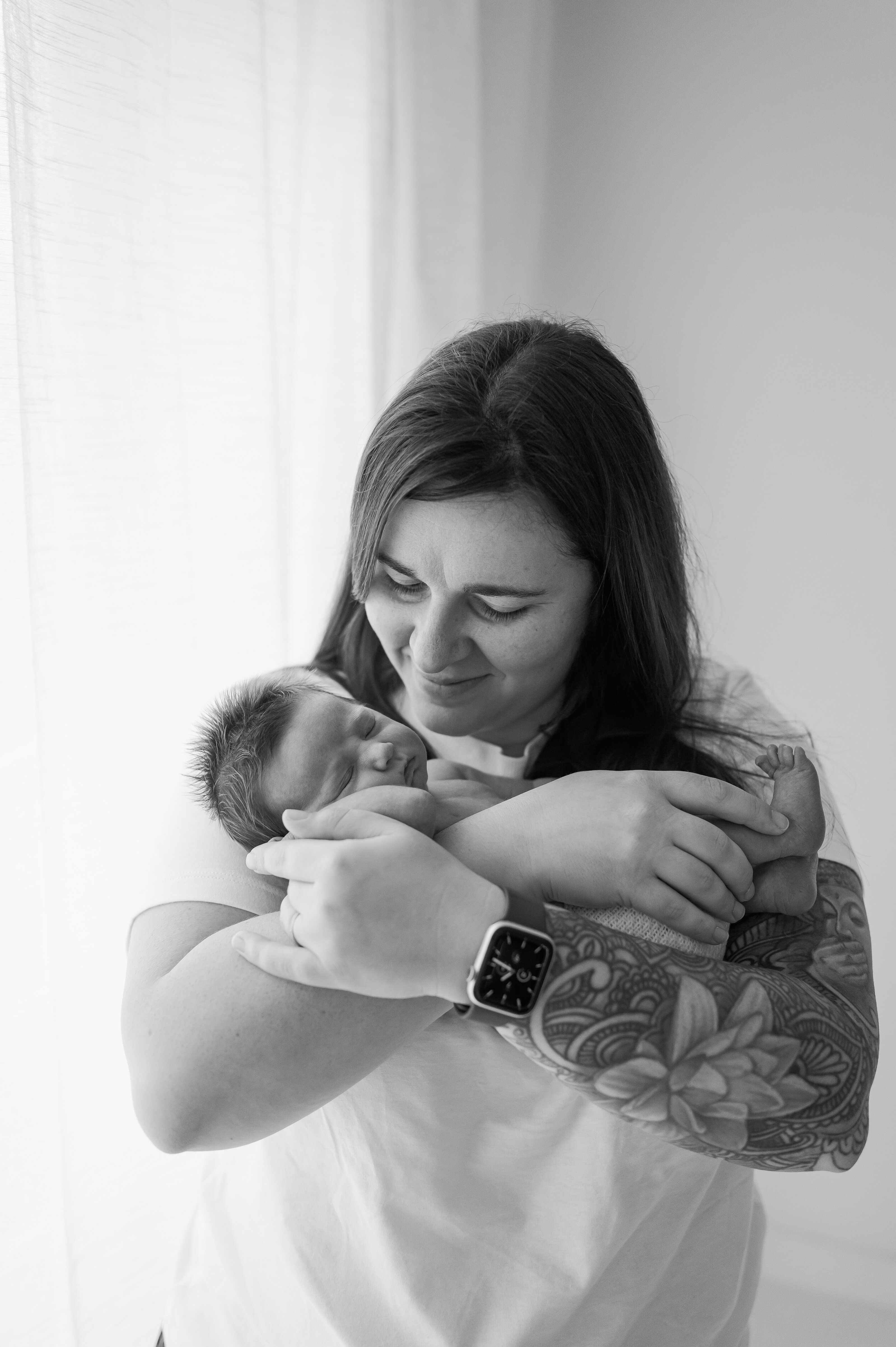 newborn baby girl twin being held by Mum at York newborn photography studio near me