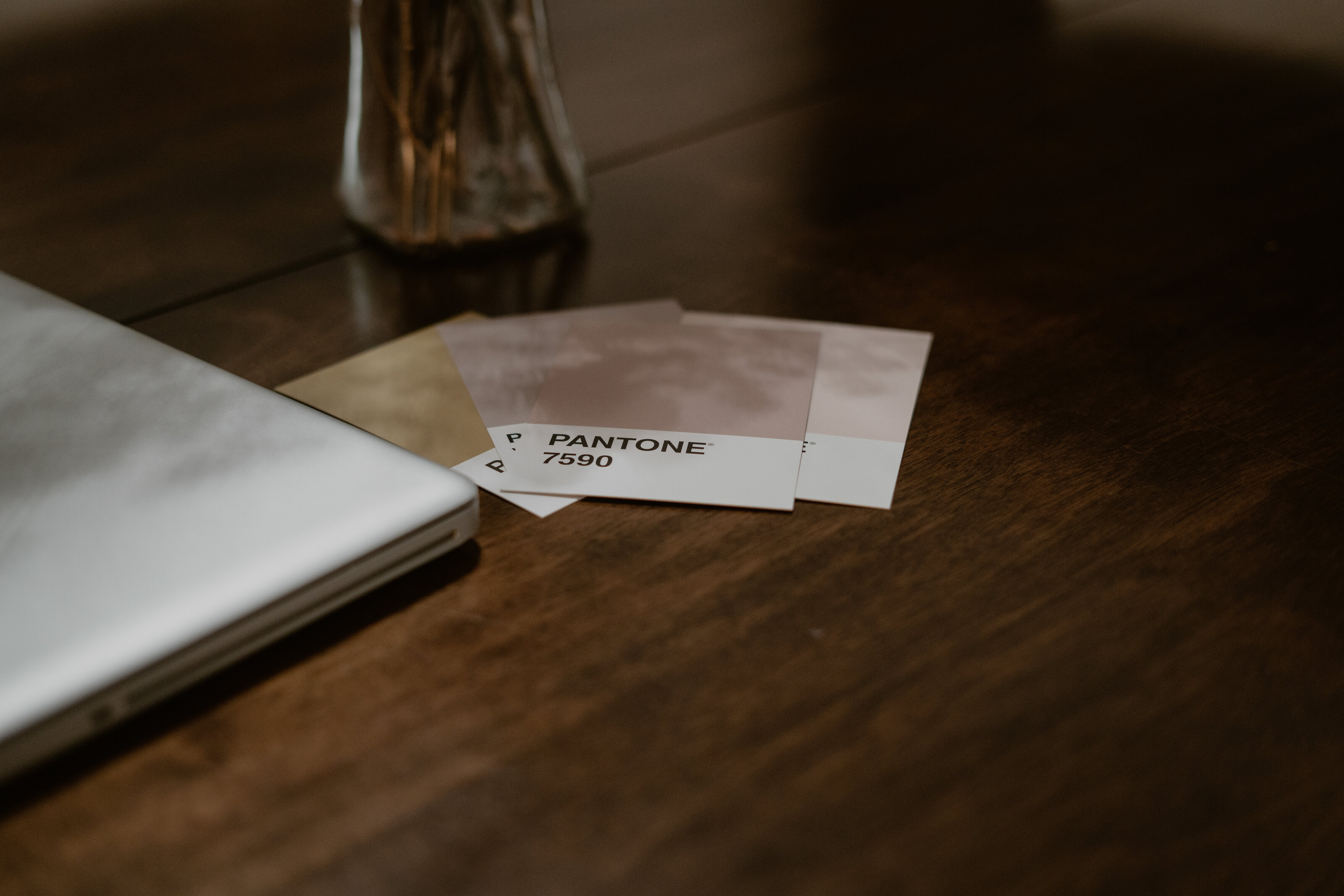Pantone color swatches sitting on a wooden grain table