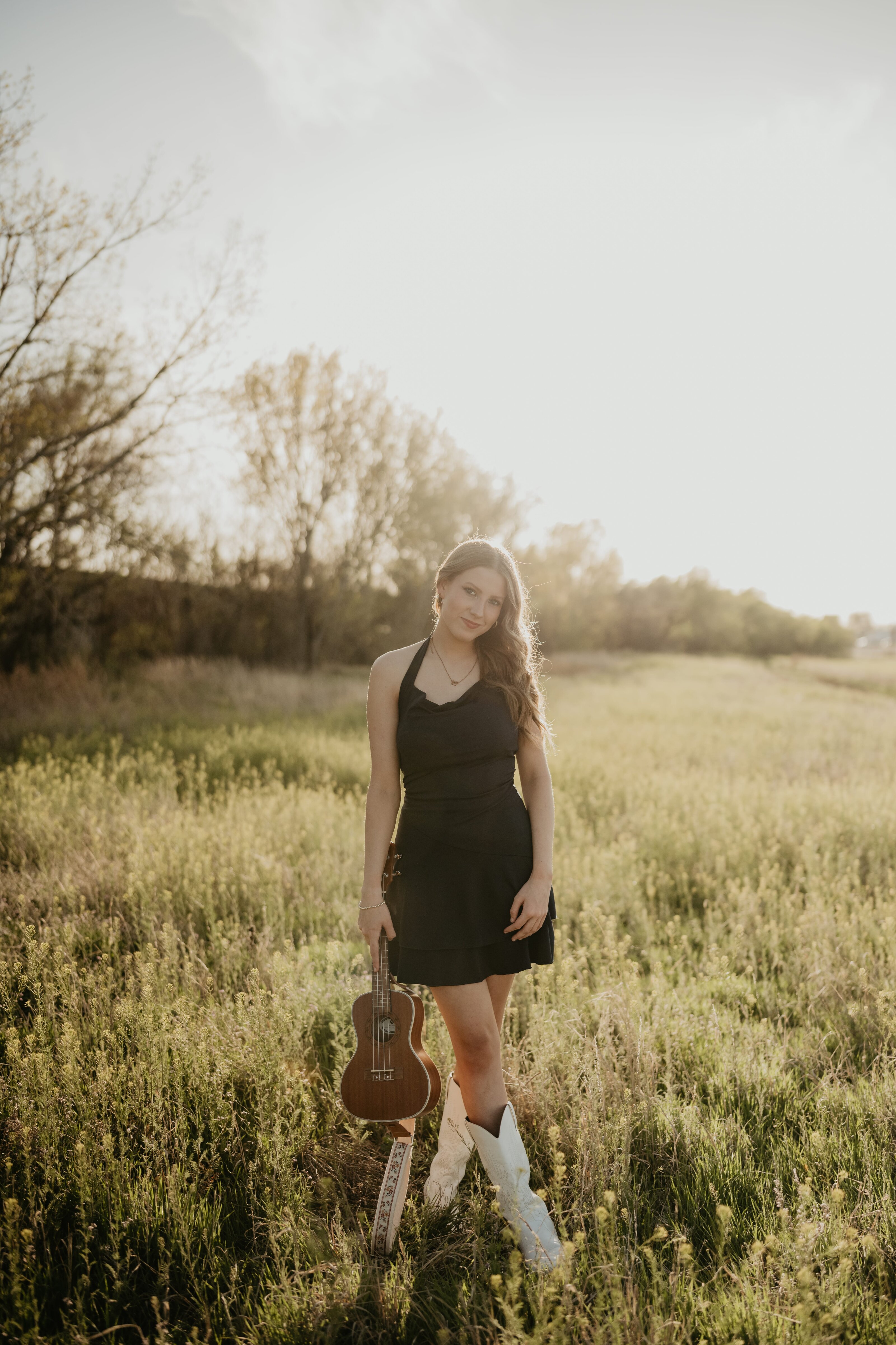 senior holding ukulele in field, senior photographer in amarillo texas
