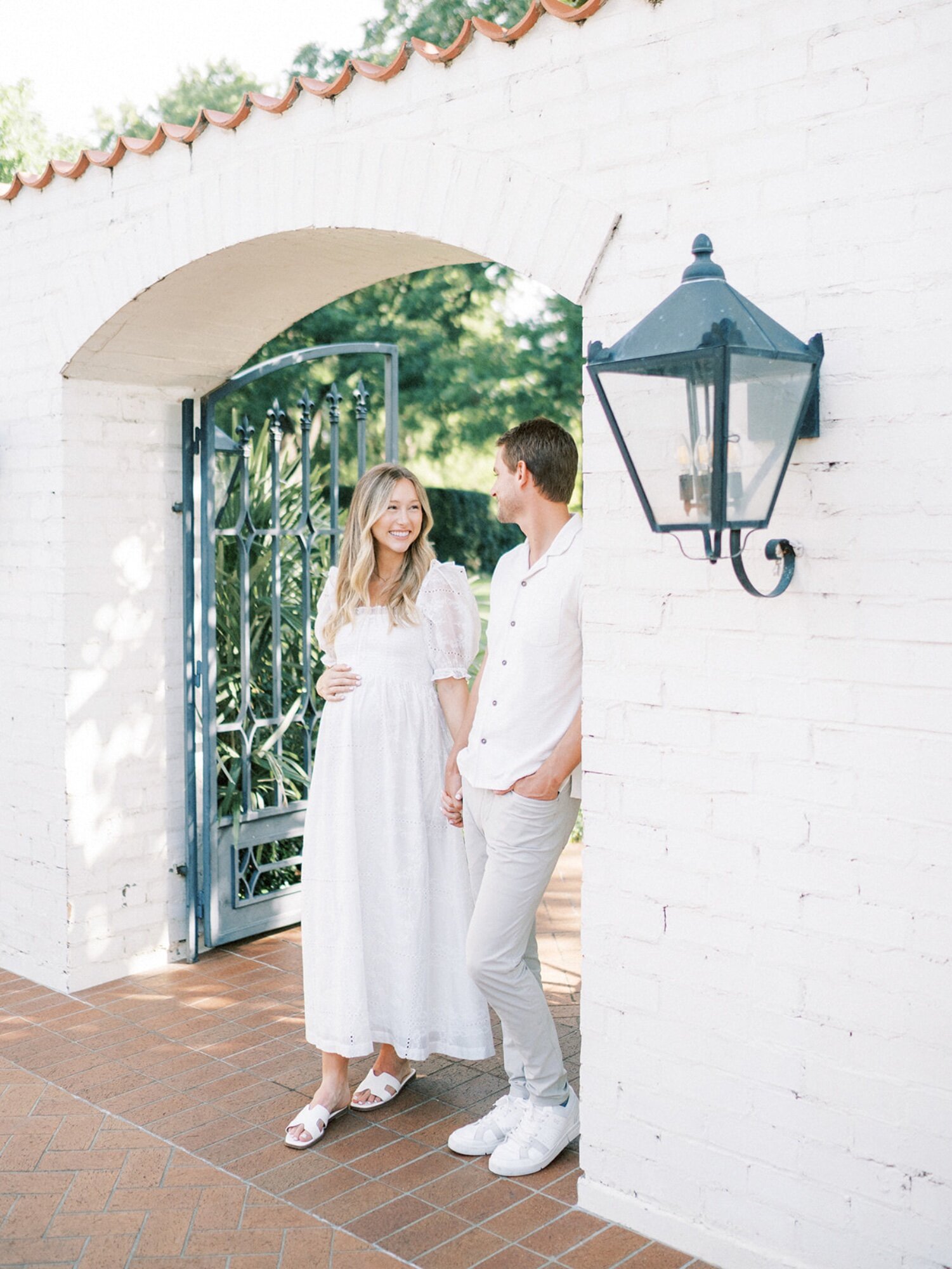 Pregnant woman and partner holding hands in Fort Worth