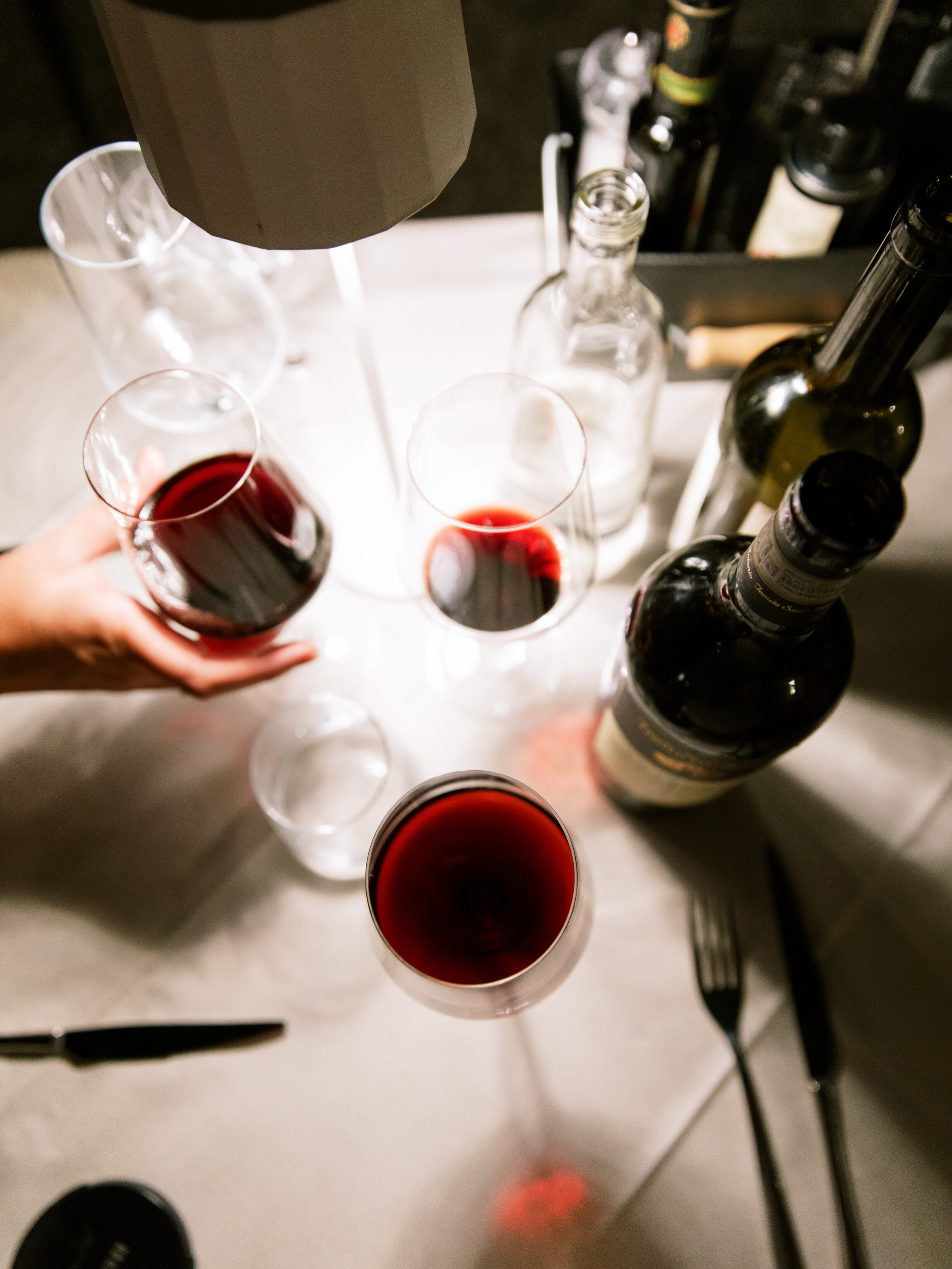 glasses and bottles of red wine sitting on a table