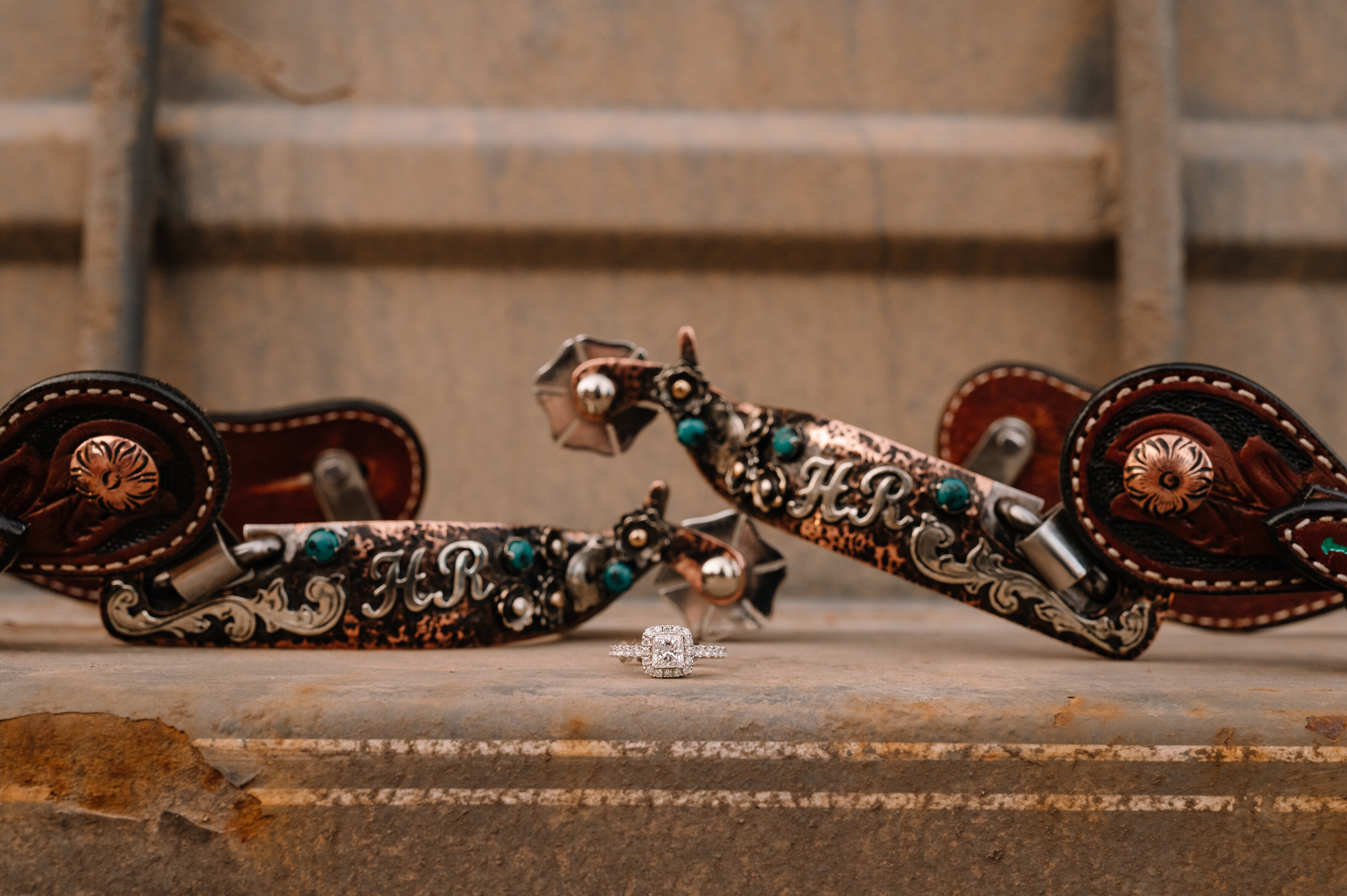 A wedding ring sitting between a set of spurs