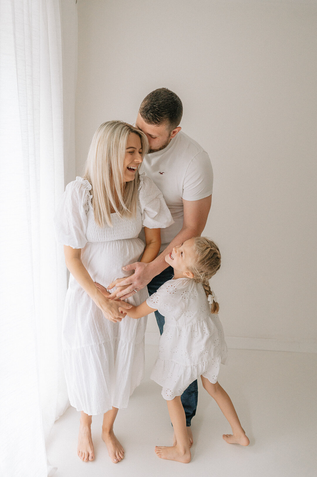 pregnant mum to be with older sibling laughing with Dad