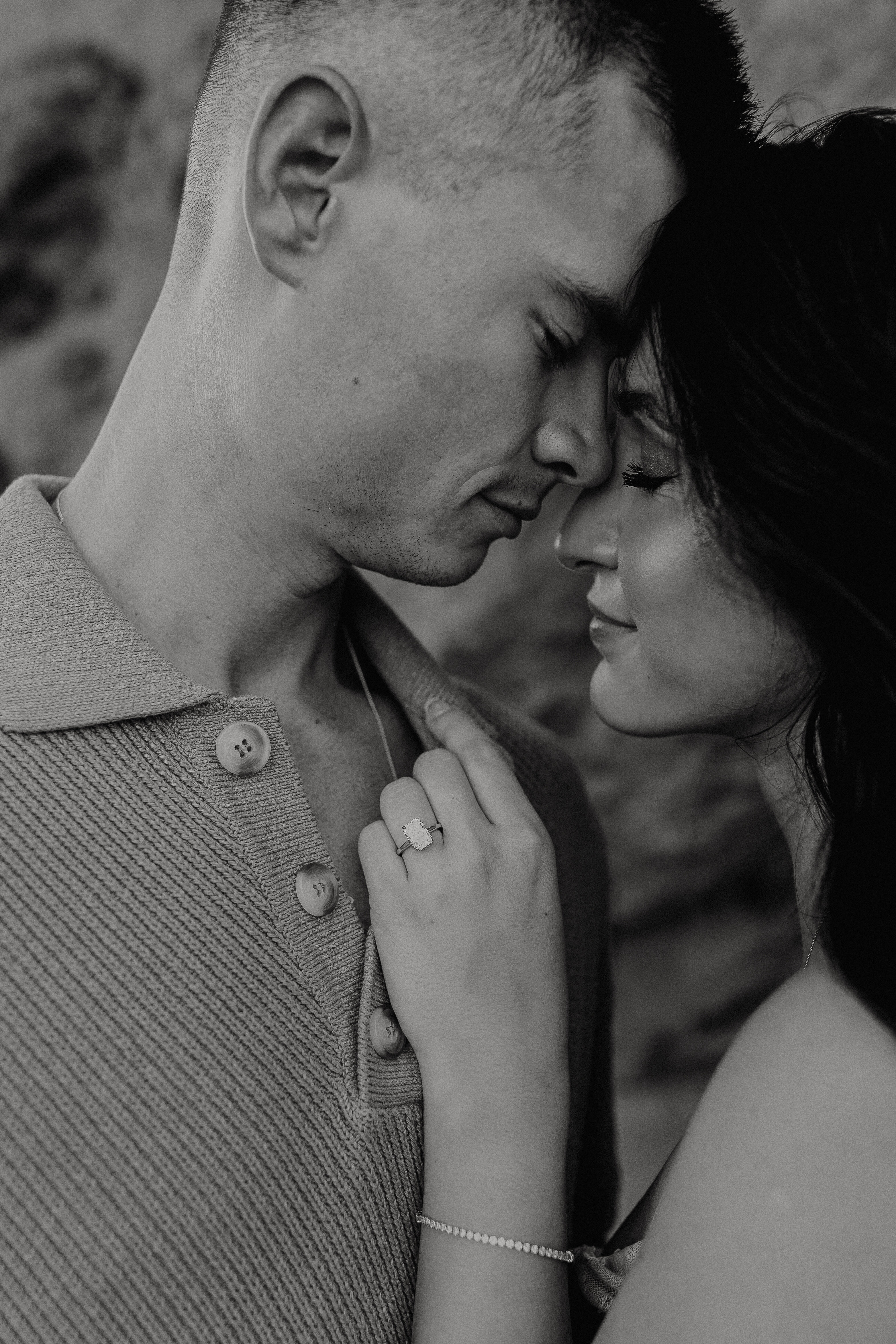 black and white close up shot of a couple while they are touching foreheads