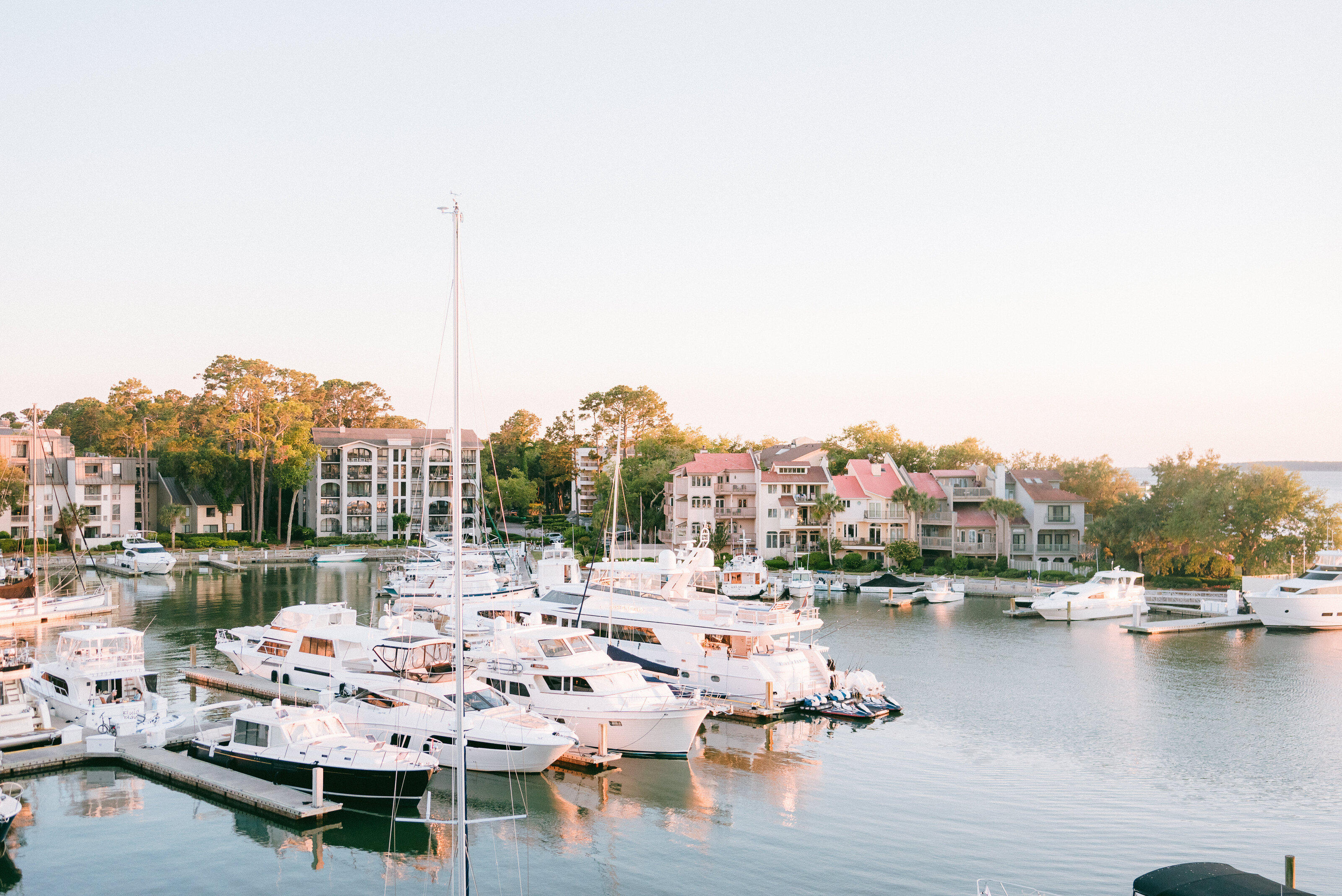 A serene view of the luxurious yacht harbor at Sea Pines, Hilton Head Island, capturing the perfect backdrop for a sophisticated waterfront wedding. Amia Marcell Photography specializes in timeless and elegant wedding photography, highlighting the beauty of Sea Pines Resort for couples seeking a high-end destination wedding experience in South Carolina