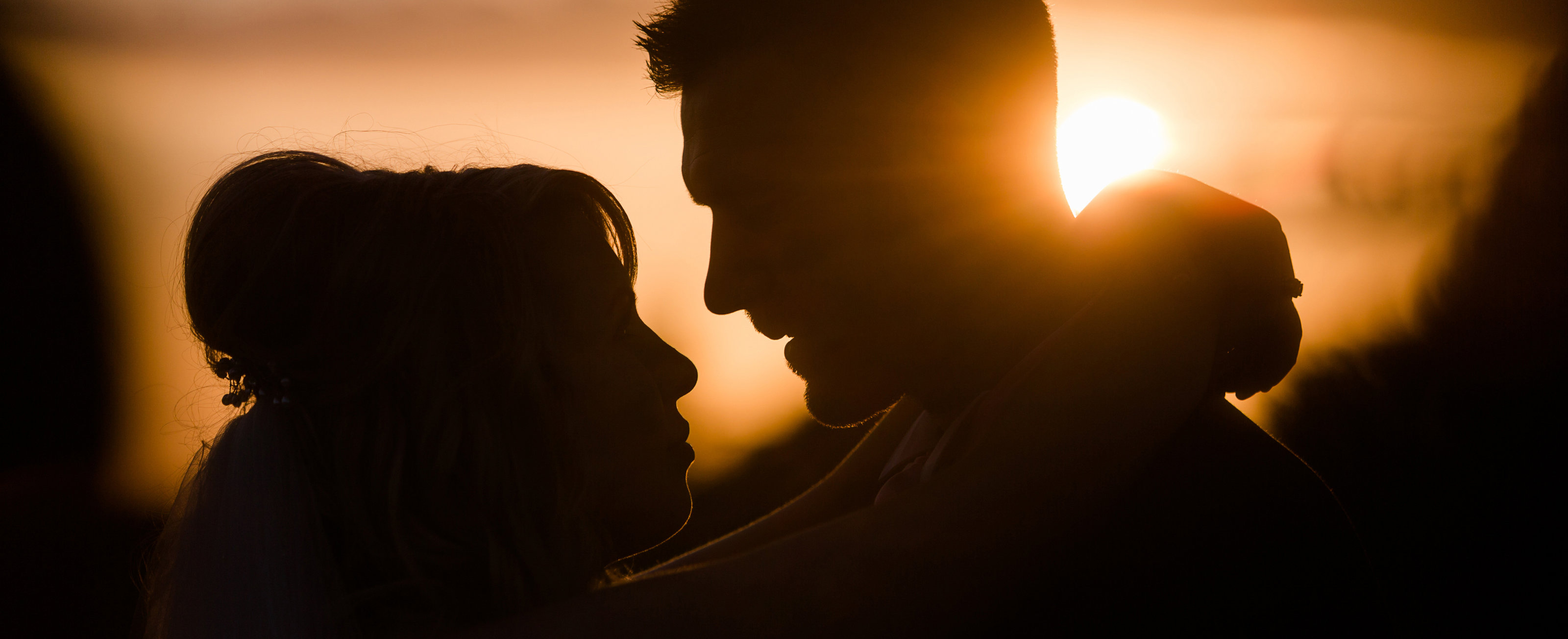 Taken by Adorlee at Golden Hour, this bride and groom have the perfect loving silhoutte embraced for the wedding portraits at sunset