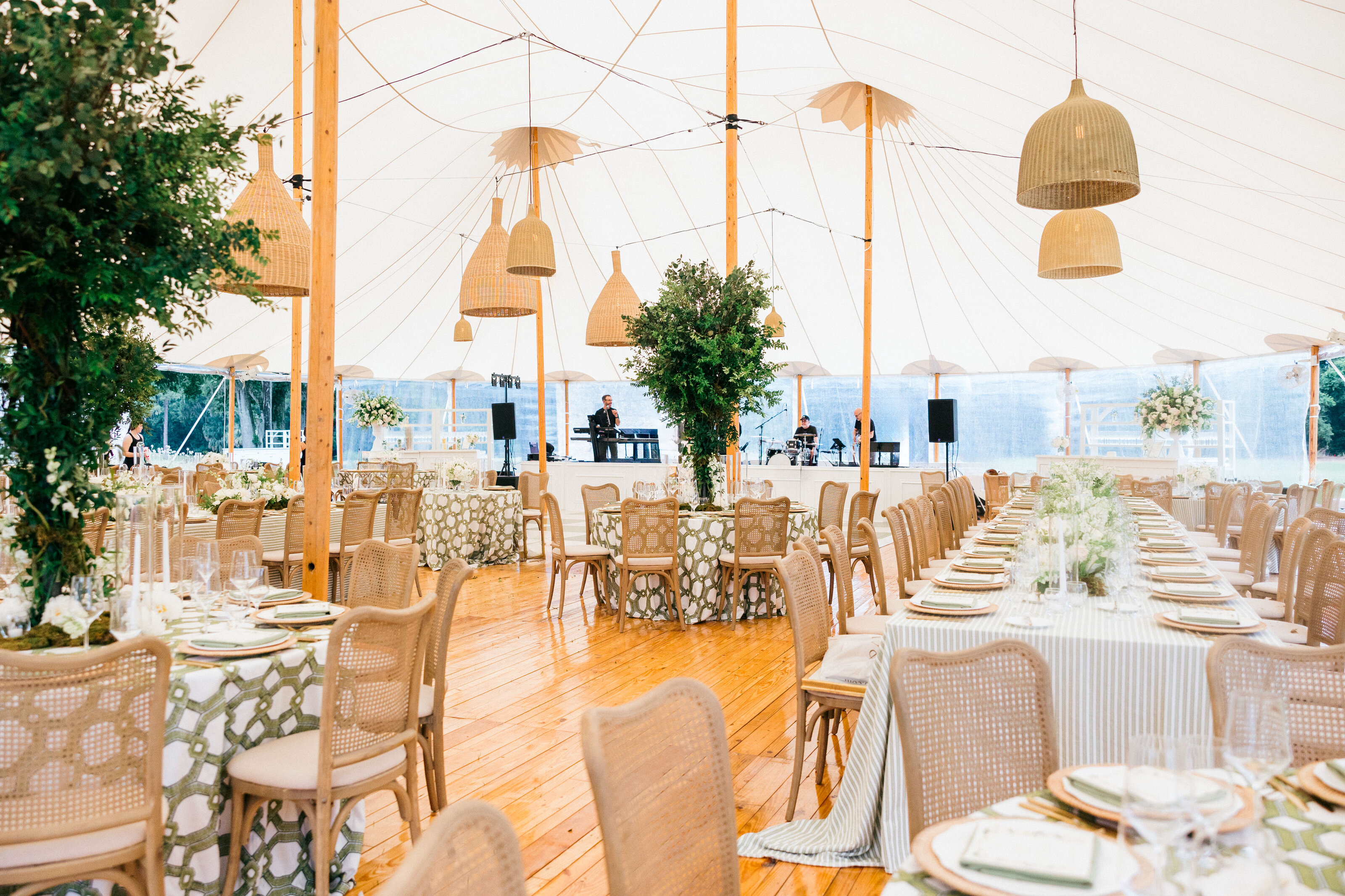 An elegant tented wedding reception at Spring Island, South Carolina, featuring woven chandeliers, greenery centerpieces, and refined natural decor for a luxury celebration.