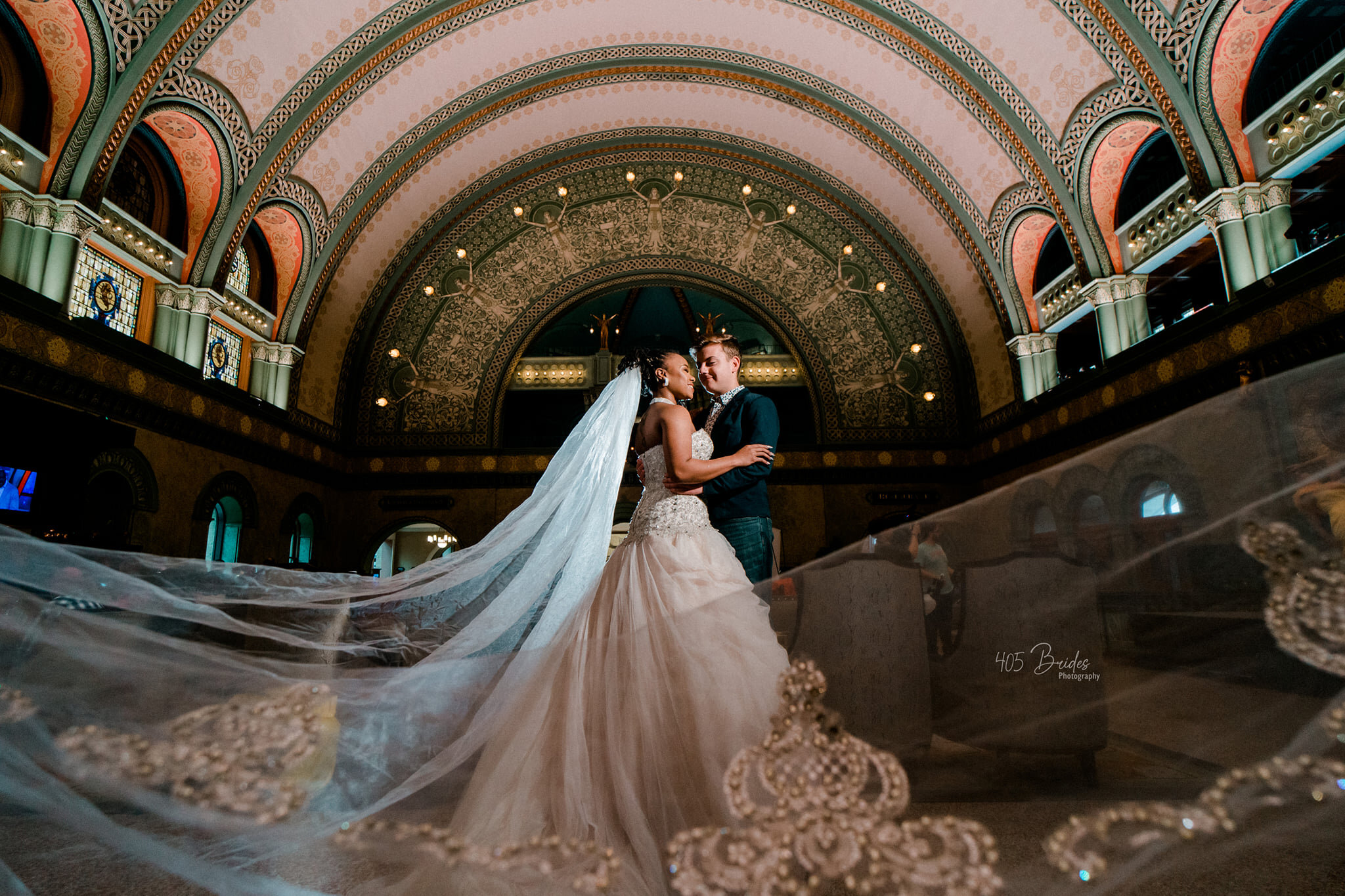 couple facing each other while veil is sweeping in front  wedding photographer