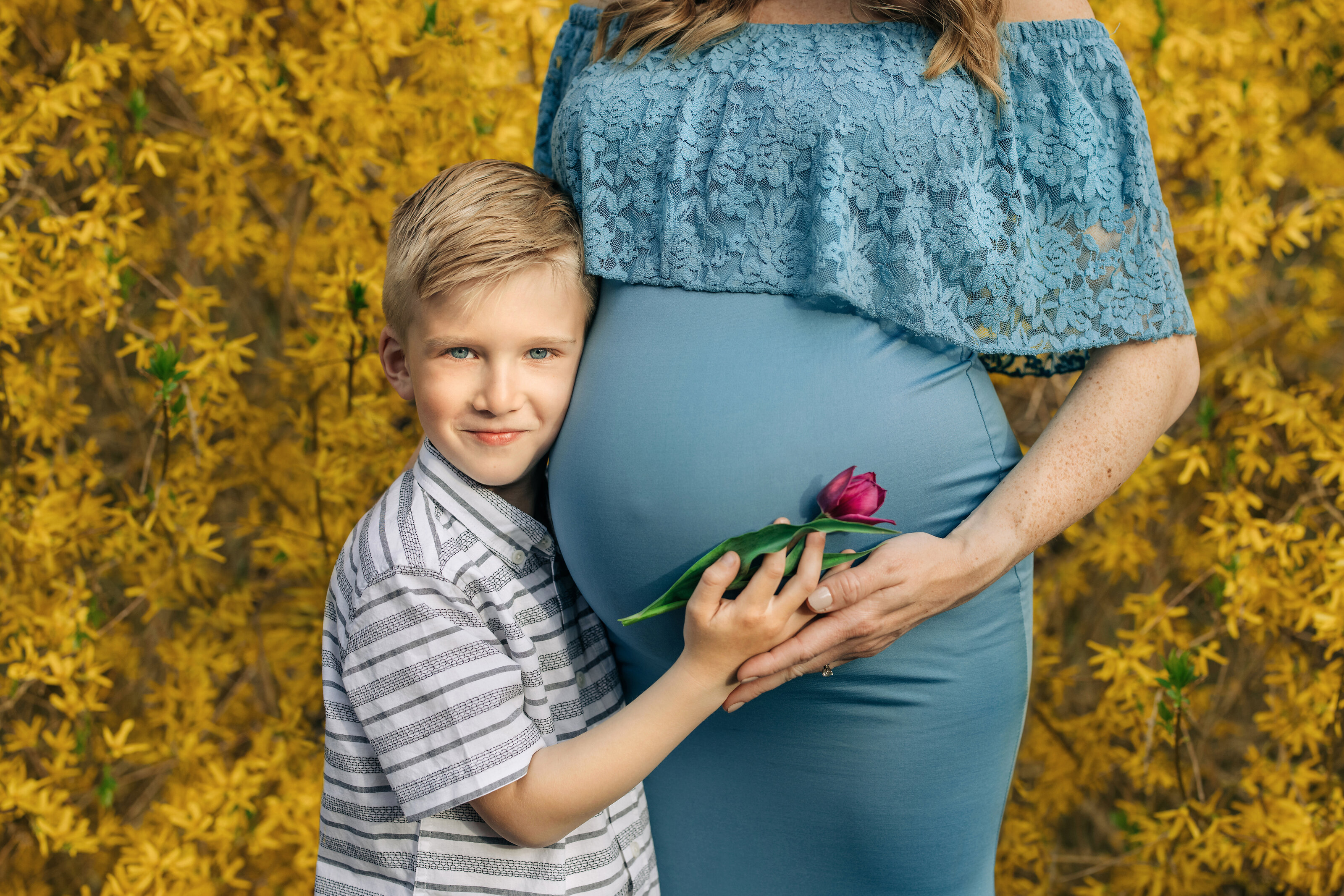 child holds pregnant moms belly during family maternity photography session in New Jersey