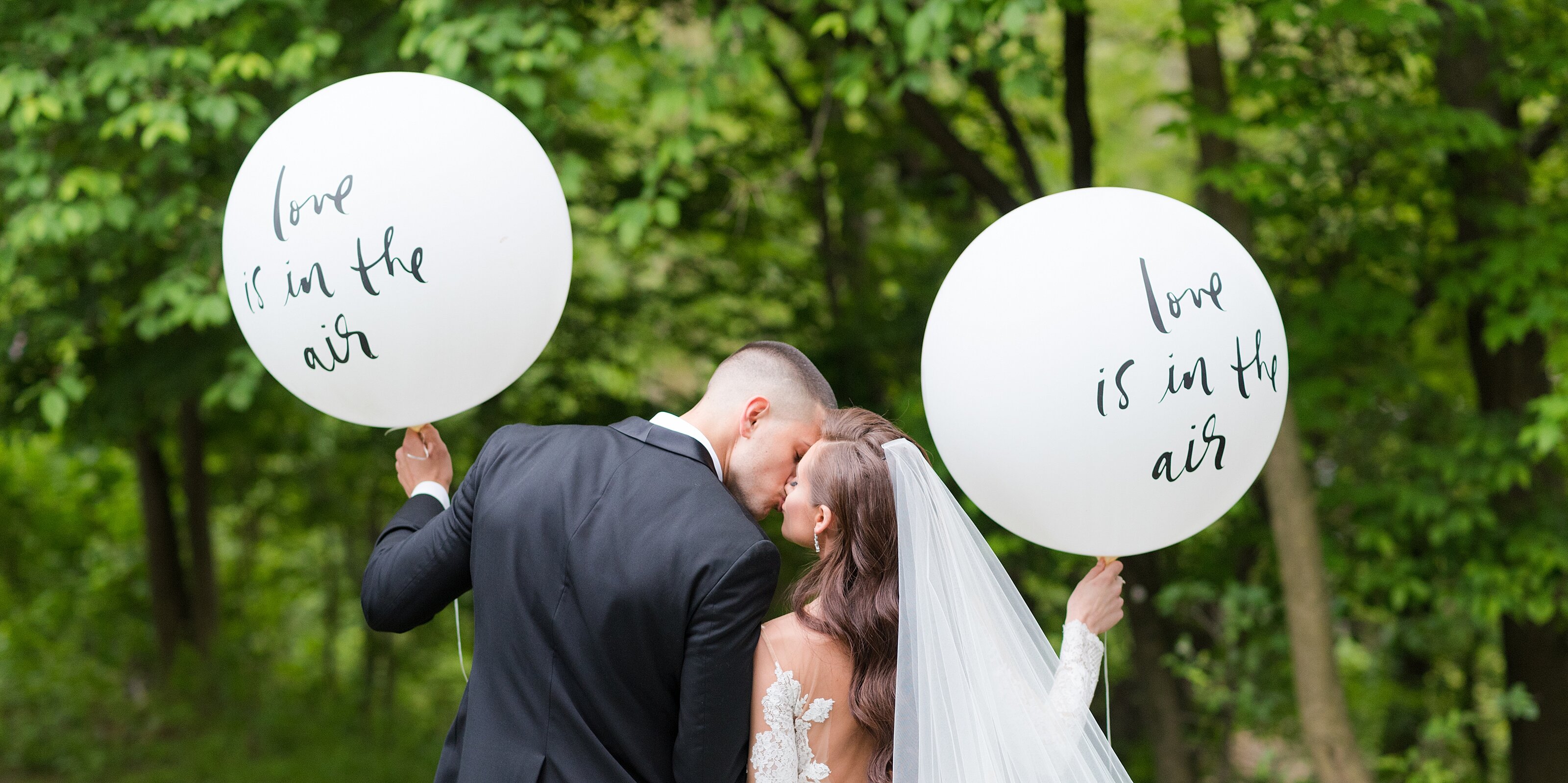5_bride-and-groom-kiss-and-hold-love-is-in-the-air-balloons