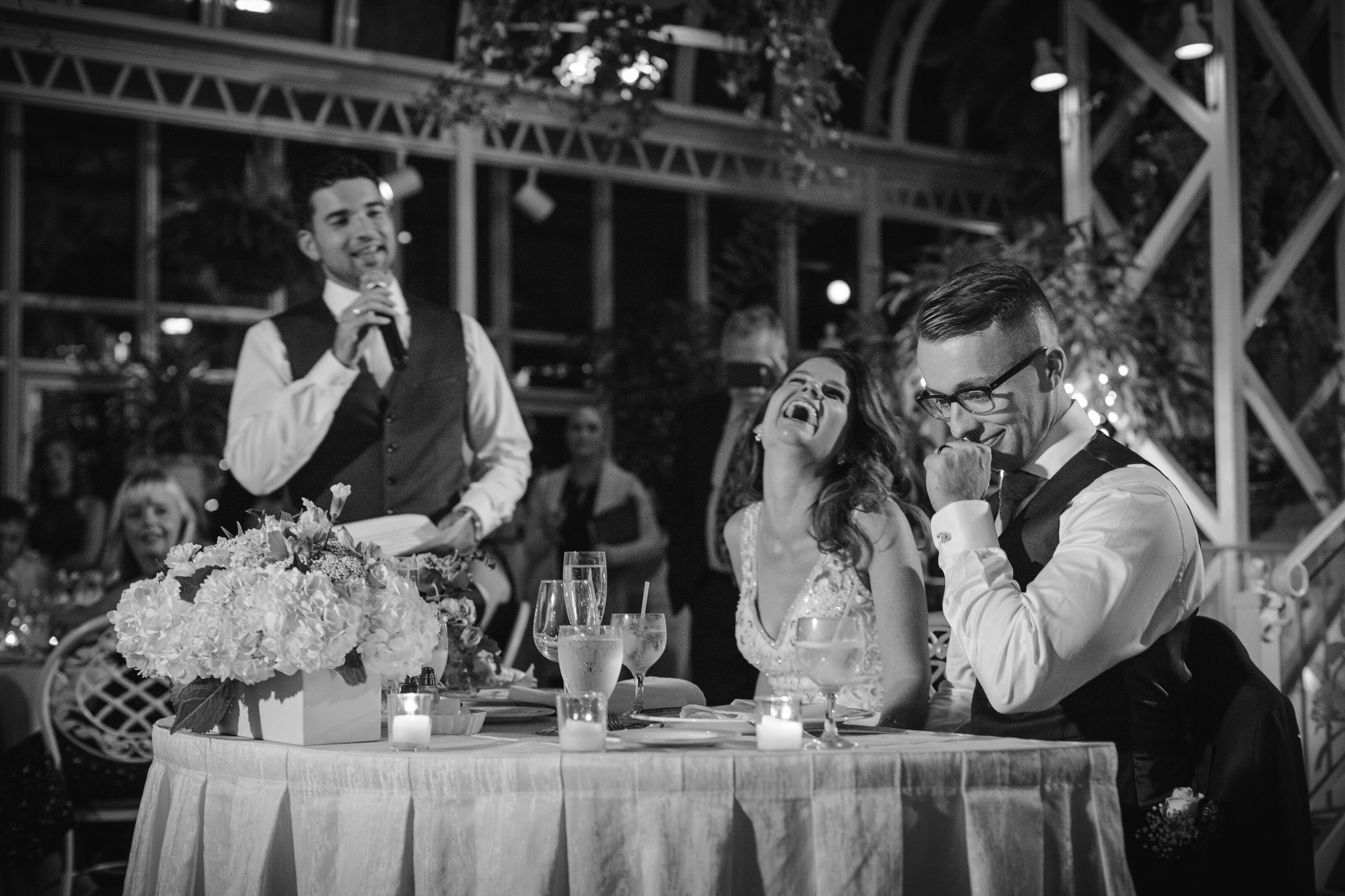 bride and groom laugh during speech, taken by best wedding photographer in New Jersey