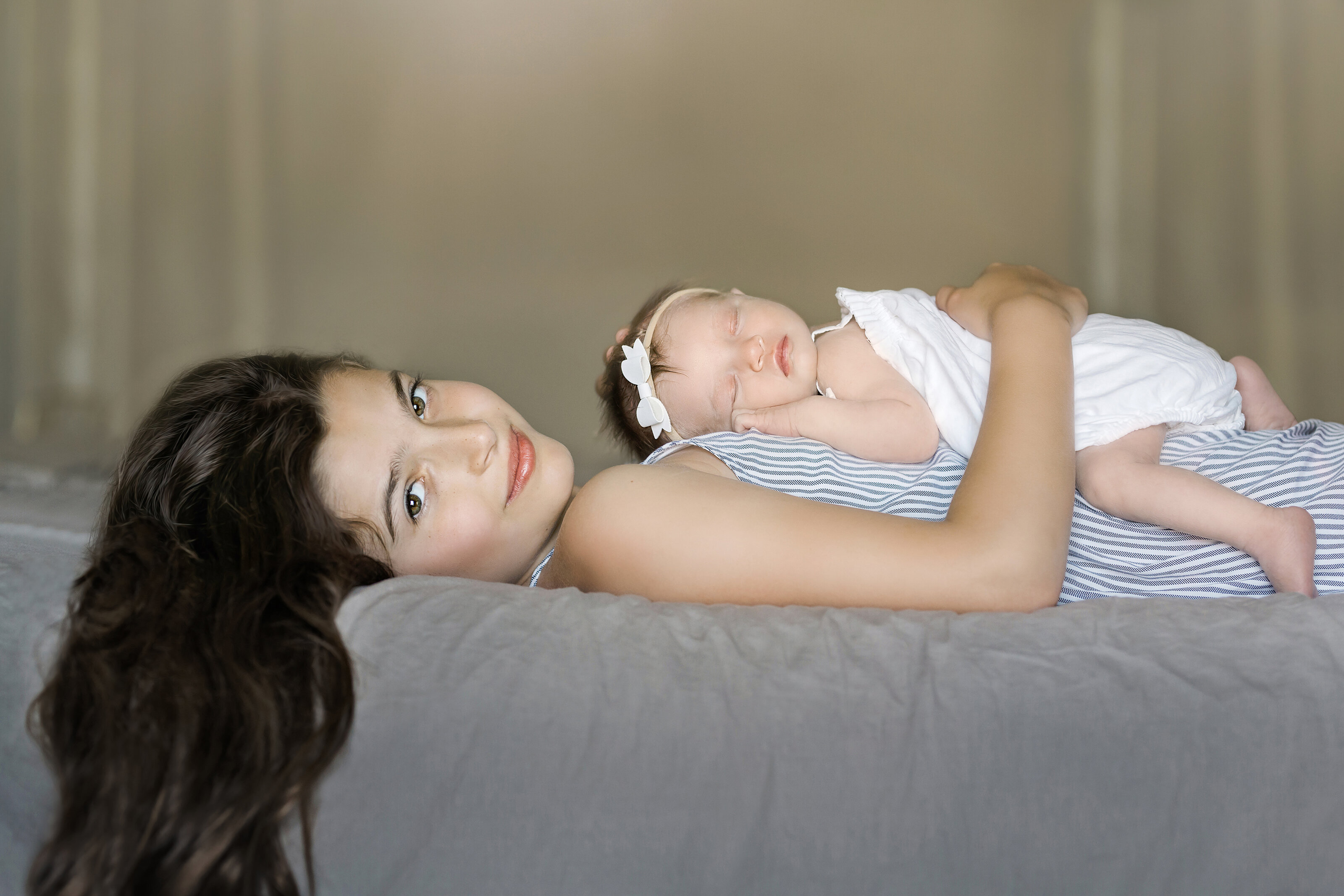 baby lays on sister for photos during newborn photography  studio session in New Jersey.