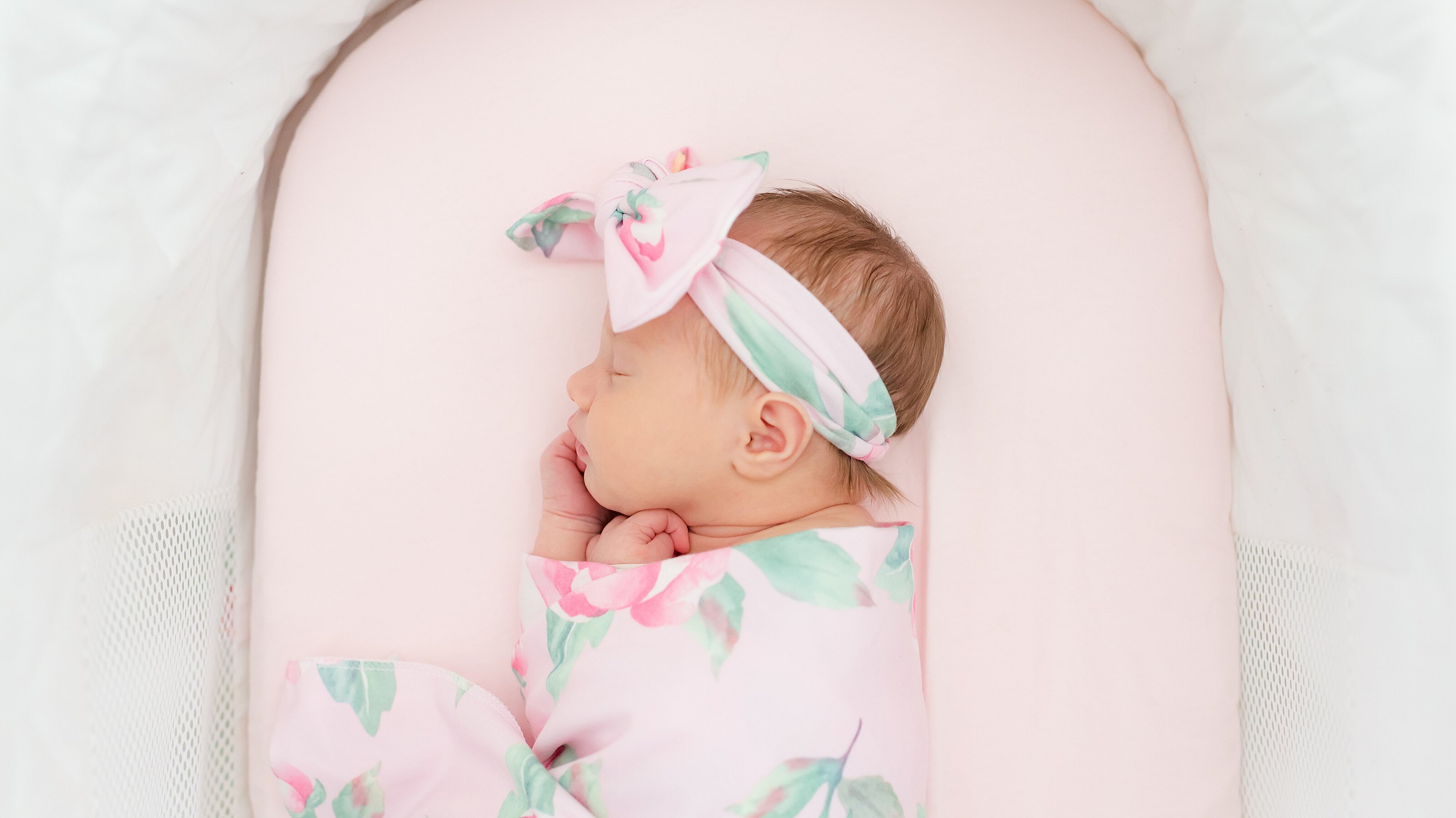 6_newborn-baby-girl-in-pink-lays-in-bassinet