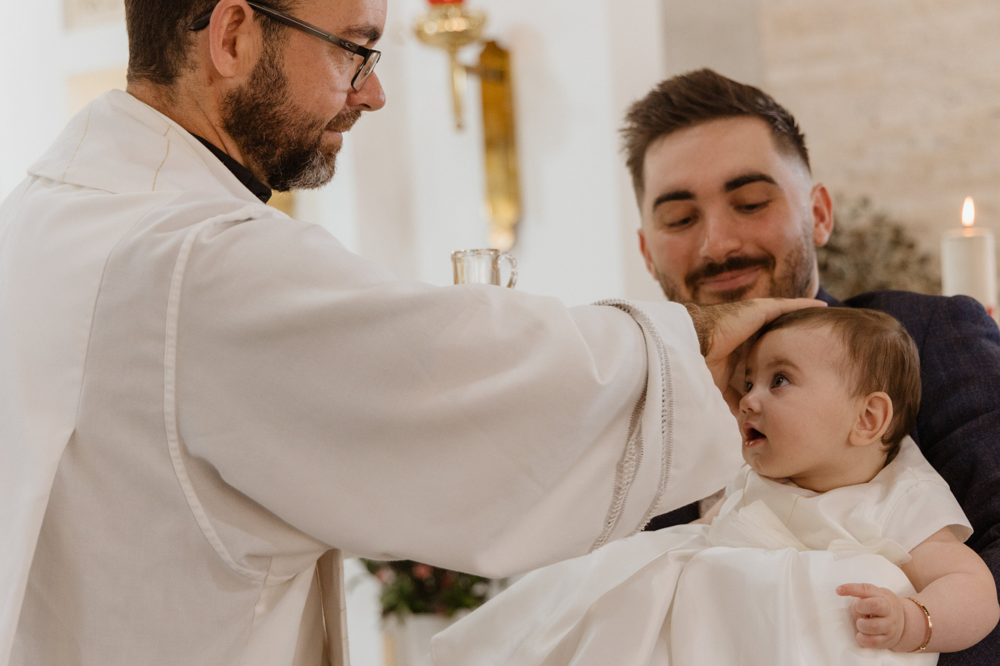 Priest blessing a baby during a christening ceremony in Perth