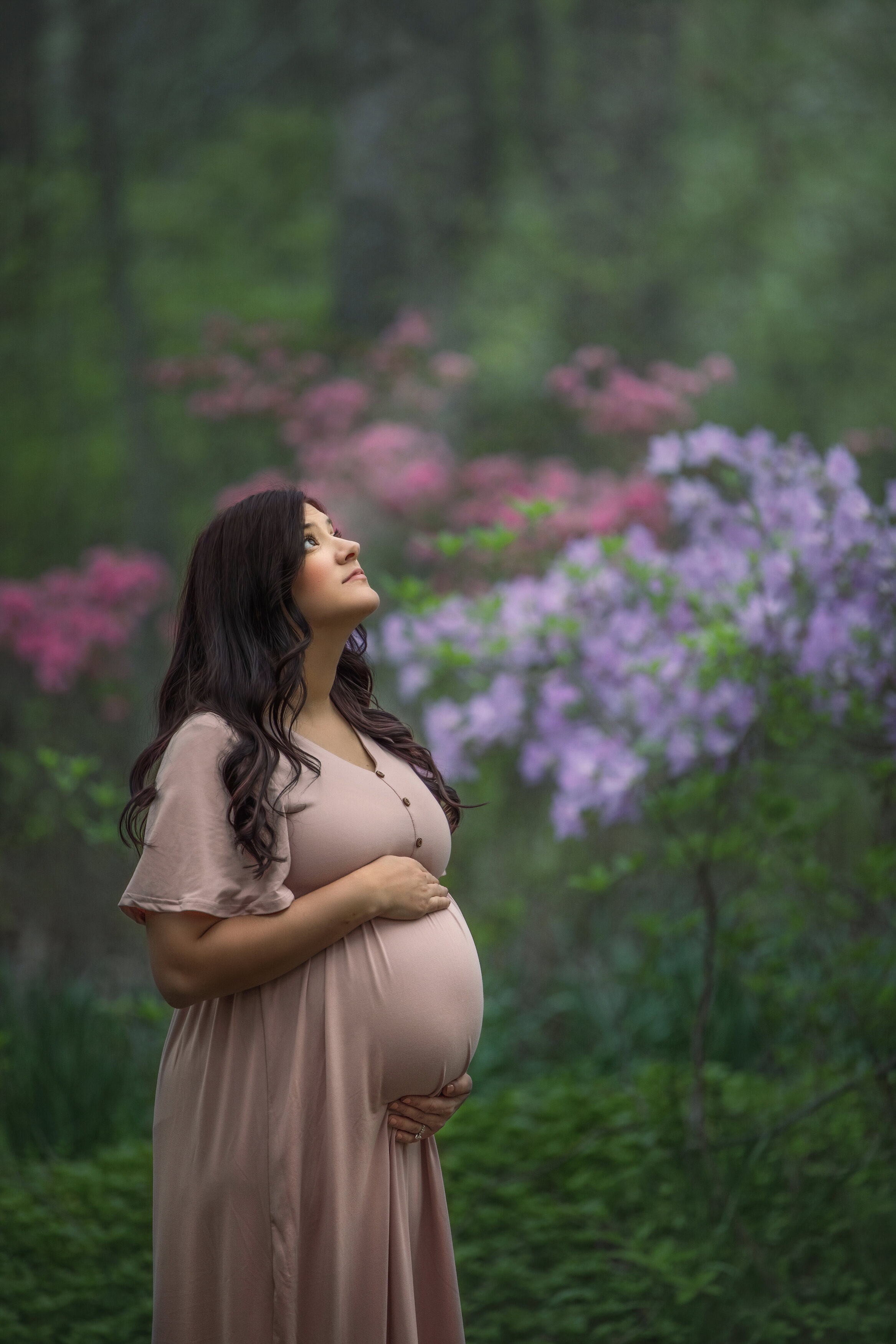 pregnant woman holds belly during outdoor maternity photography session at Sayen Gardens in Hamilton, New Jersey