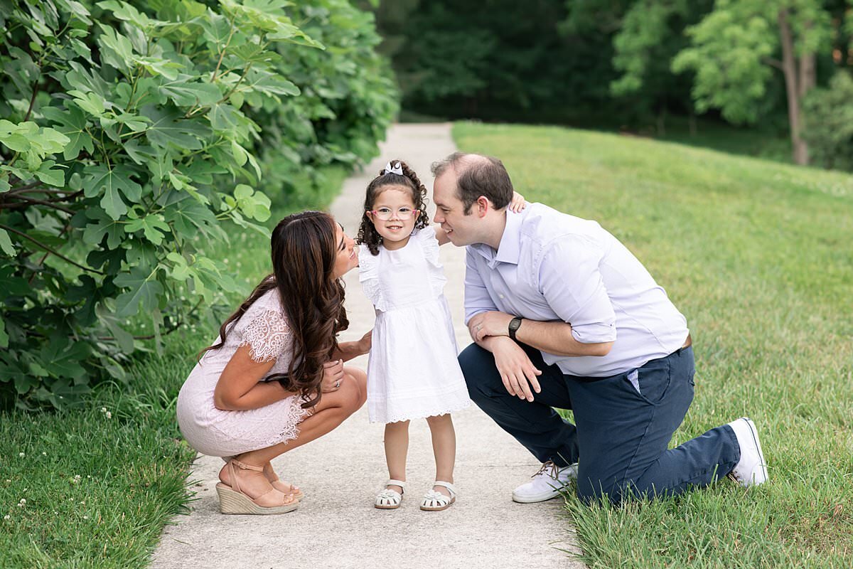 Parents looking at little girl who is smiling for Maryland Family Photographer