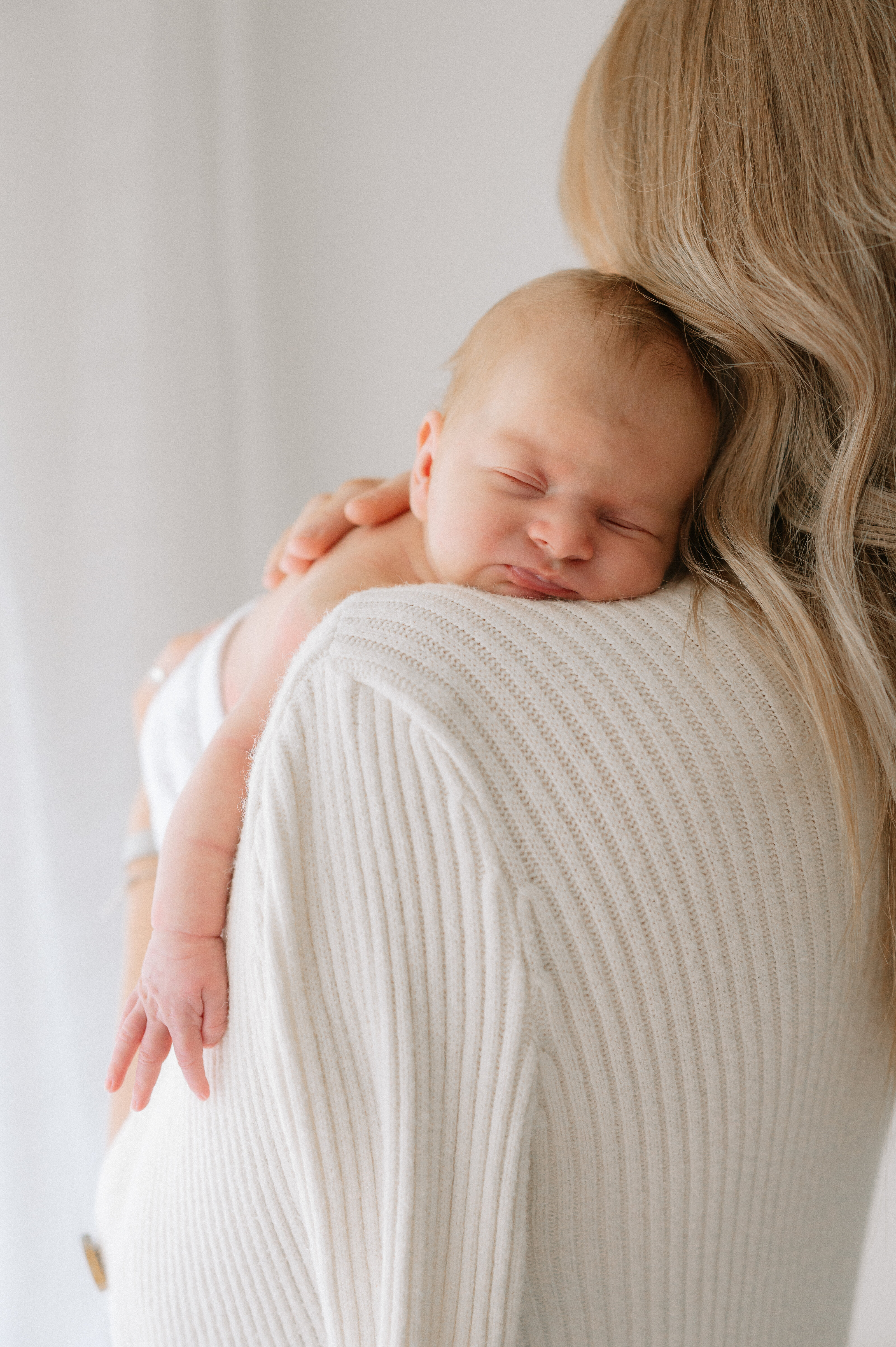close up of baby girl on Mums shoulder