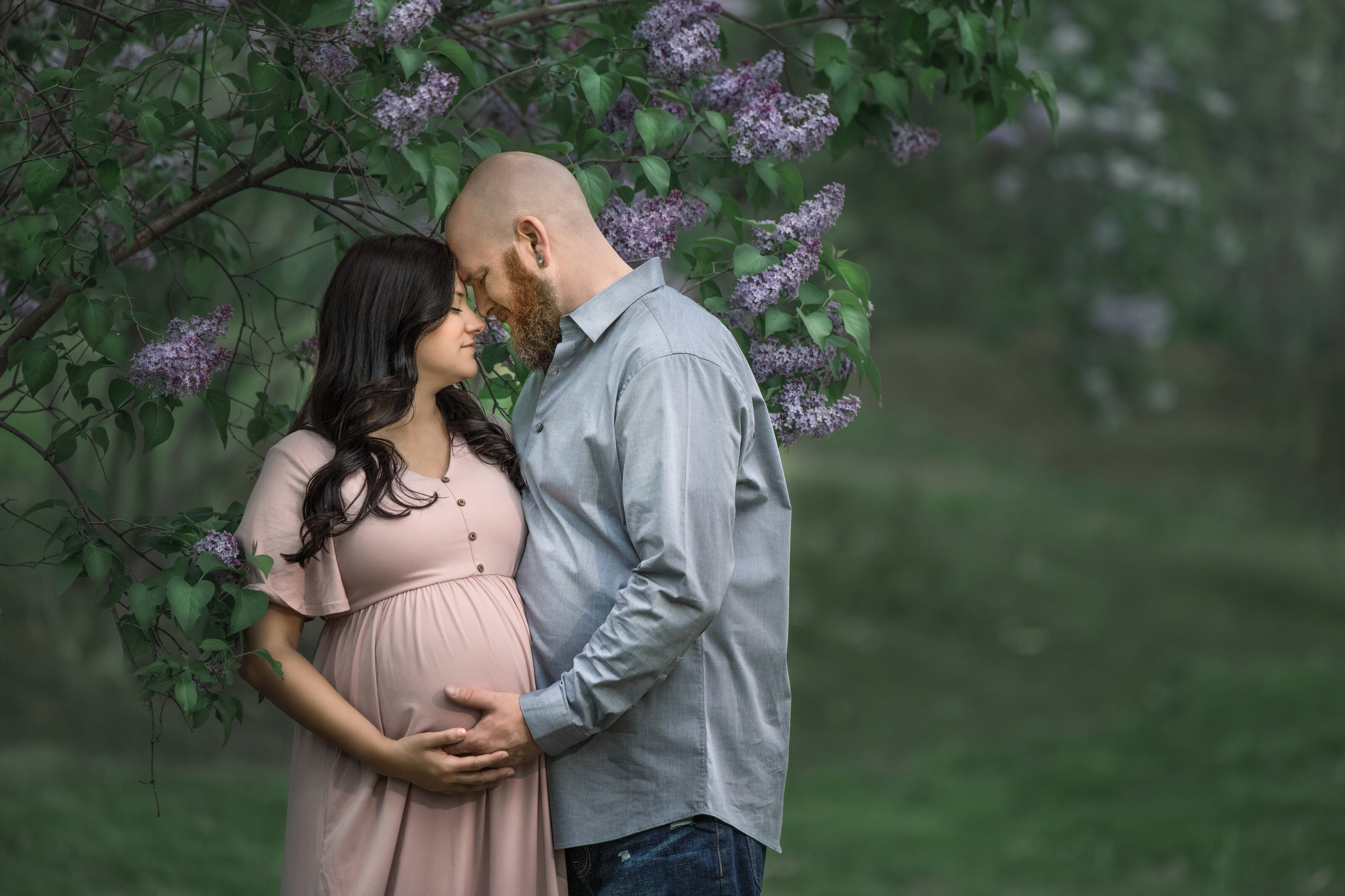 Expecting parents hold belly for photos during maternity photography shoot at Sayen Gardens in Hamilton, New Jersey