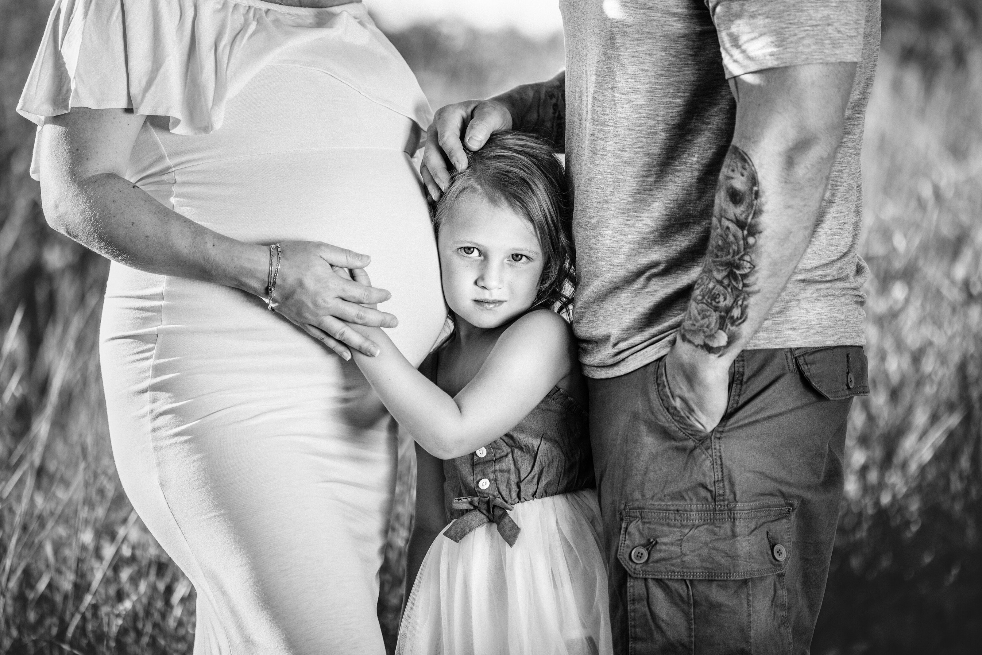 child holds pregnant moms belly during maternity photoshoot in Hamilton, New Jersey