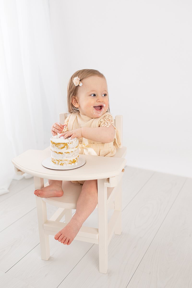 Cake smash with baby girl in a high chair by Maryland Portrait Photographer : Rebecca Leigh Photography