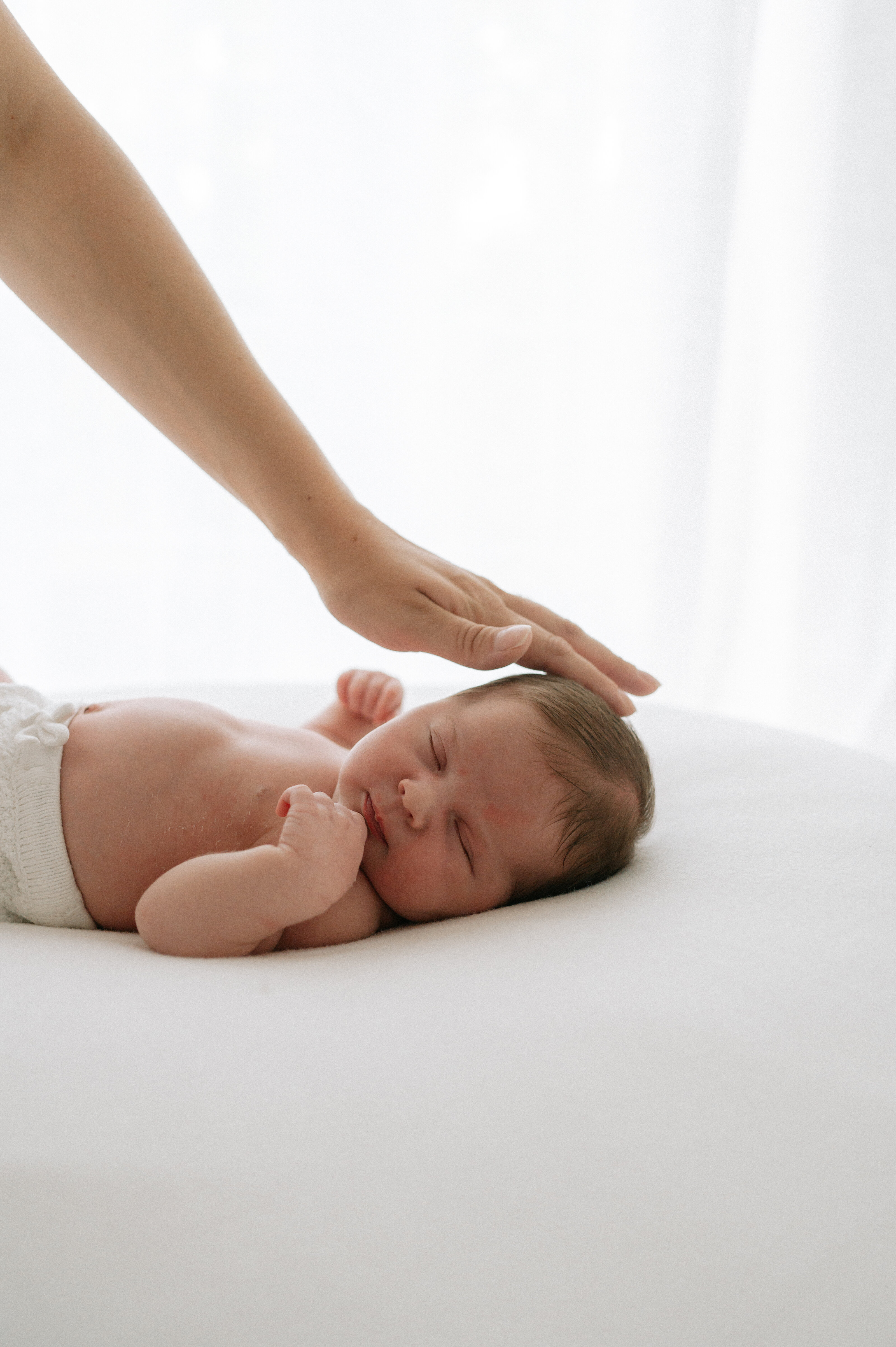 Mum stroking newborn baby girls head