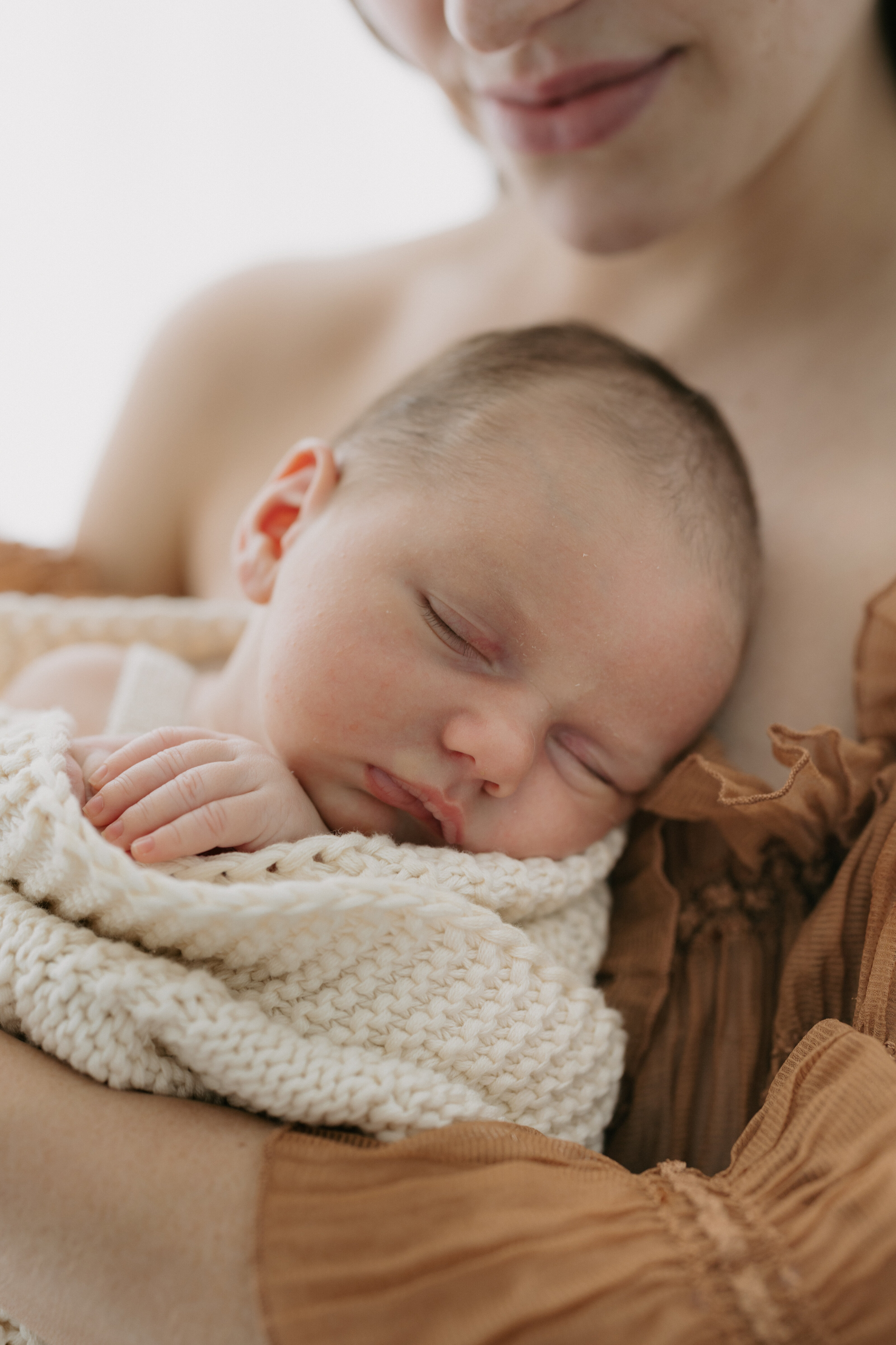 Newborn baby peacefully sleeping in a cozy indoor session in Perth