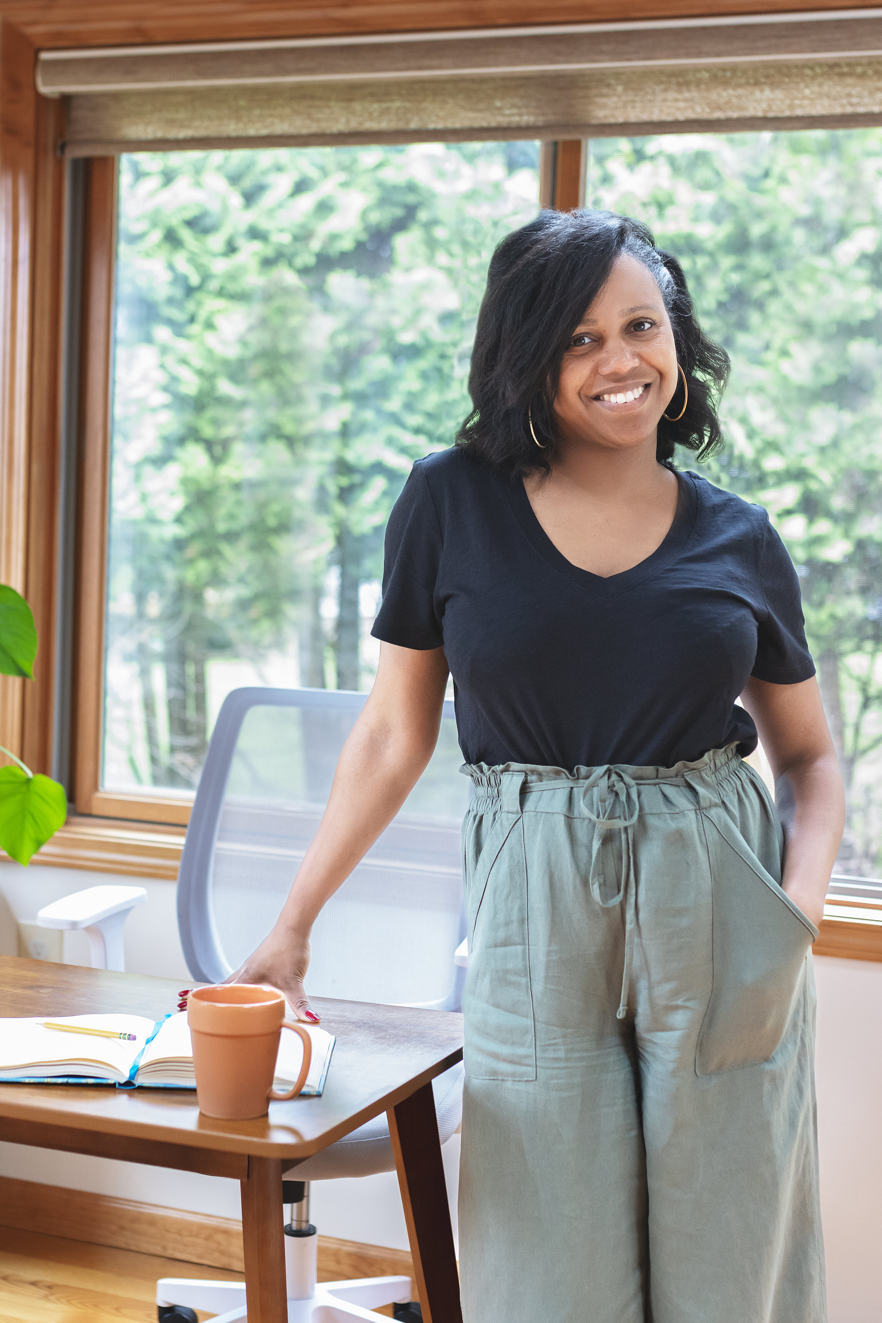 Editor standing at her desk and smiling during a lifestyle branding photography session