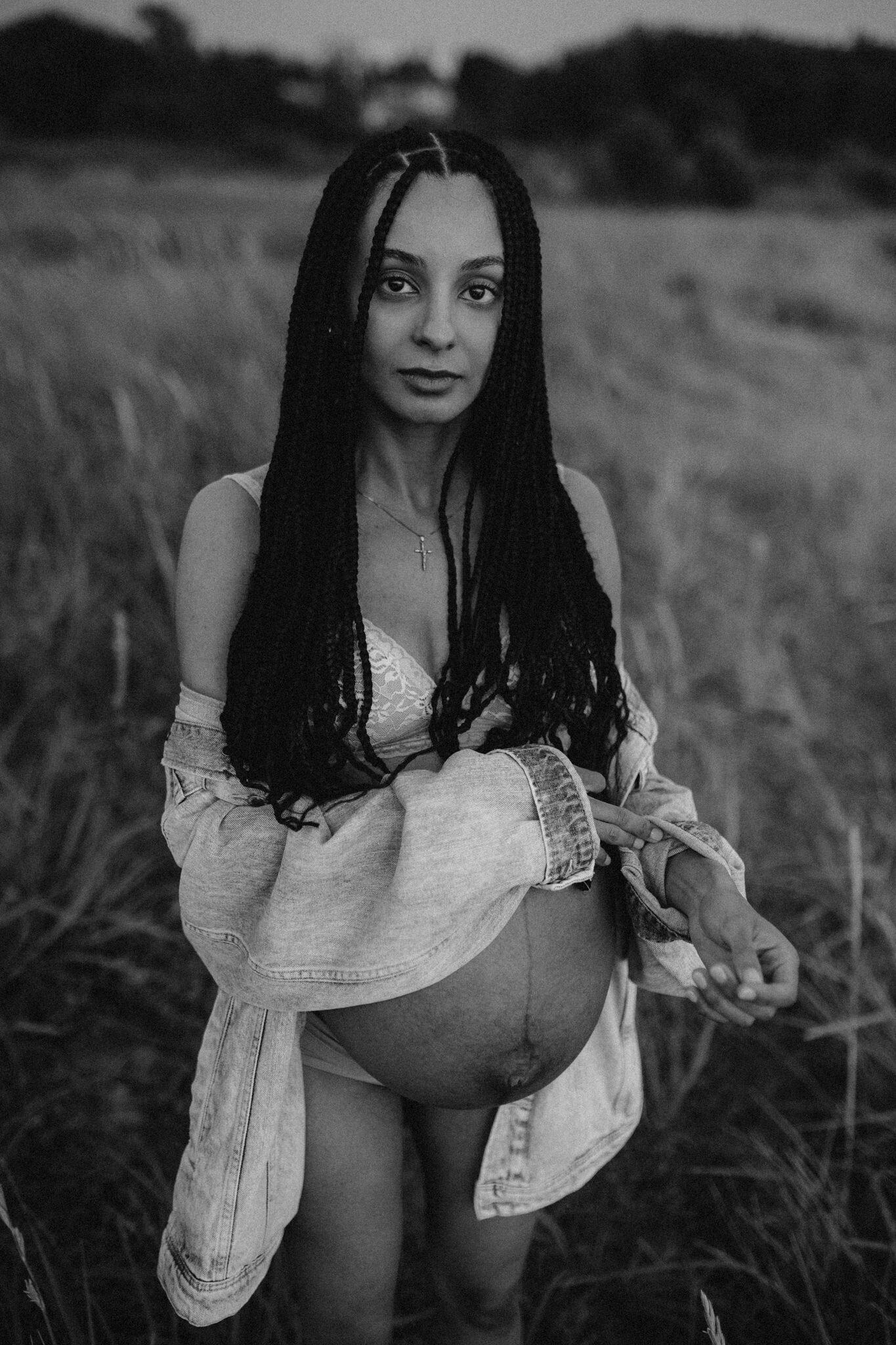 en gravid mamma med rastaflätor kollar in starkt i kameran