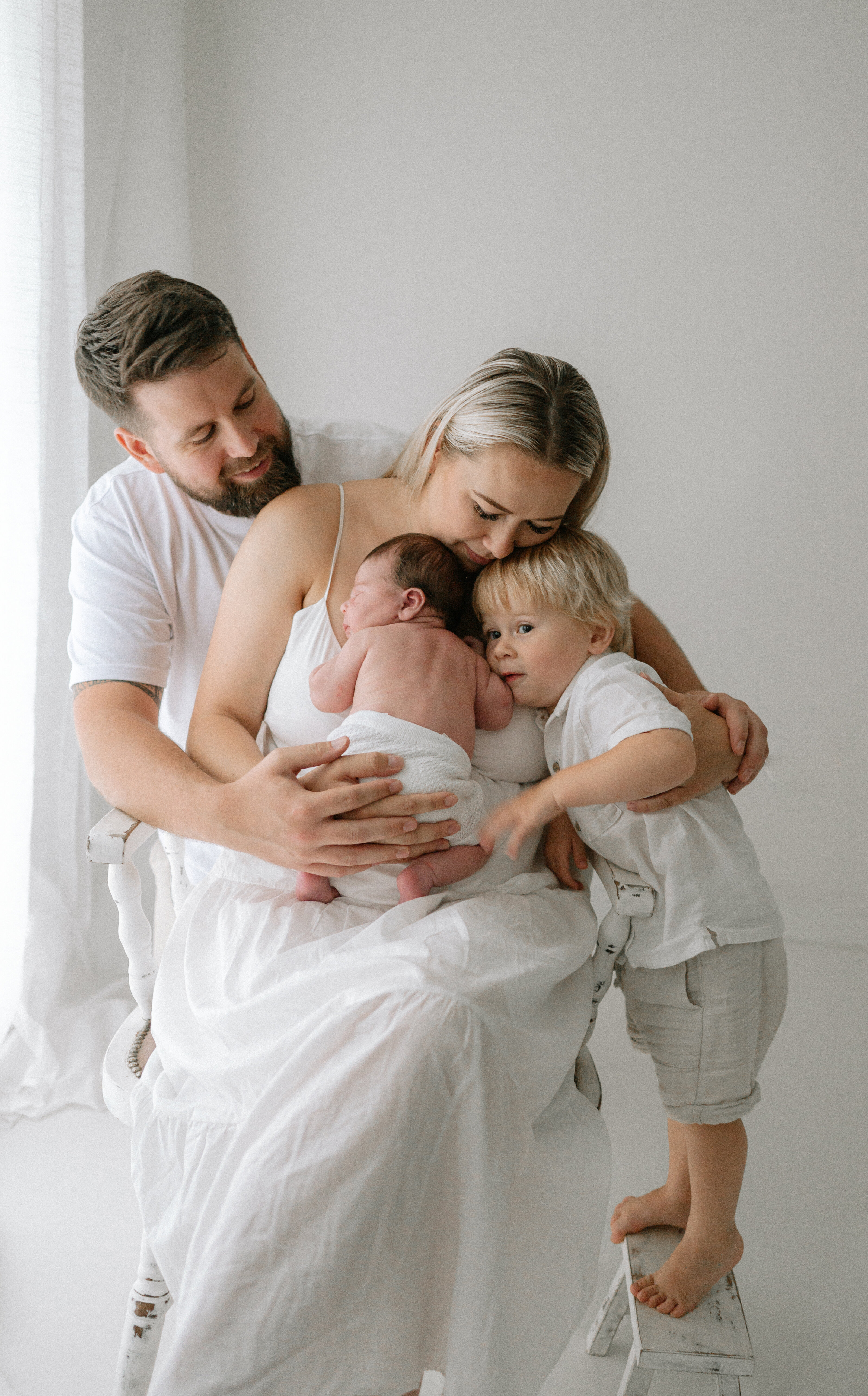 family photography - Mum, Dad, Big Brother and Baby Sister having a close cuddle
