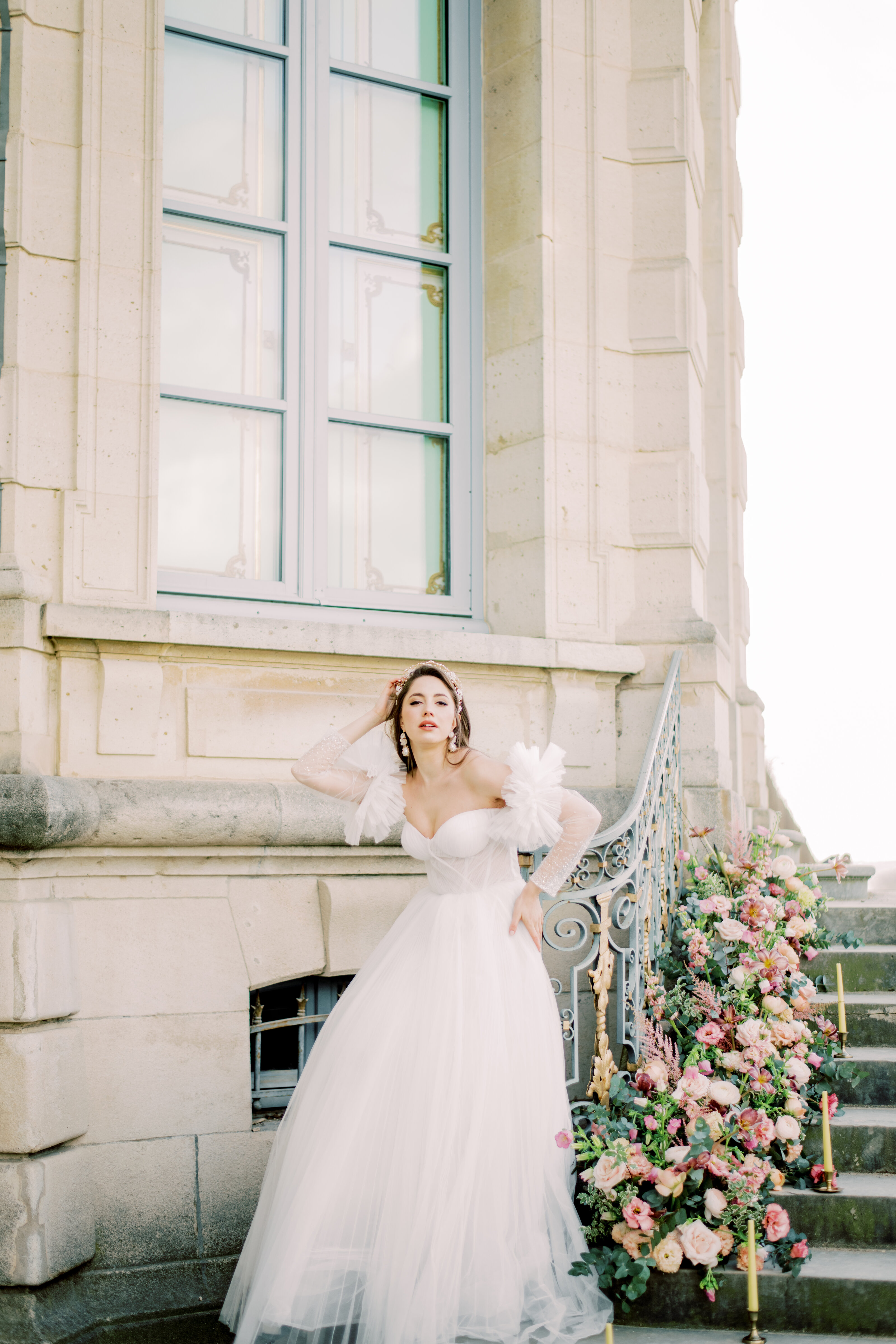 Editorial bridal portrait of a bride in a romantic tulle gown outside a European-style venue in Italy — photographed by a luxury wedding photographer.