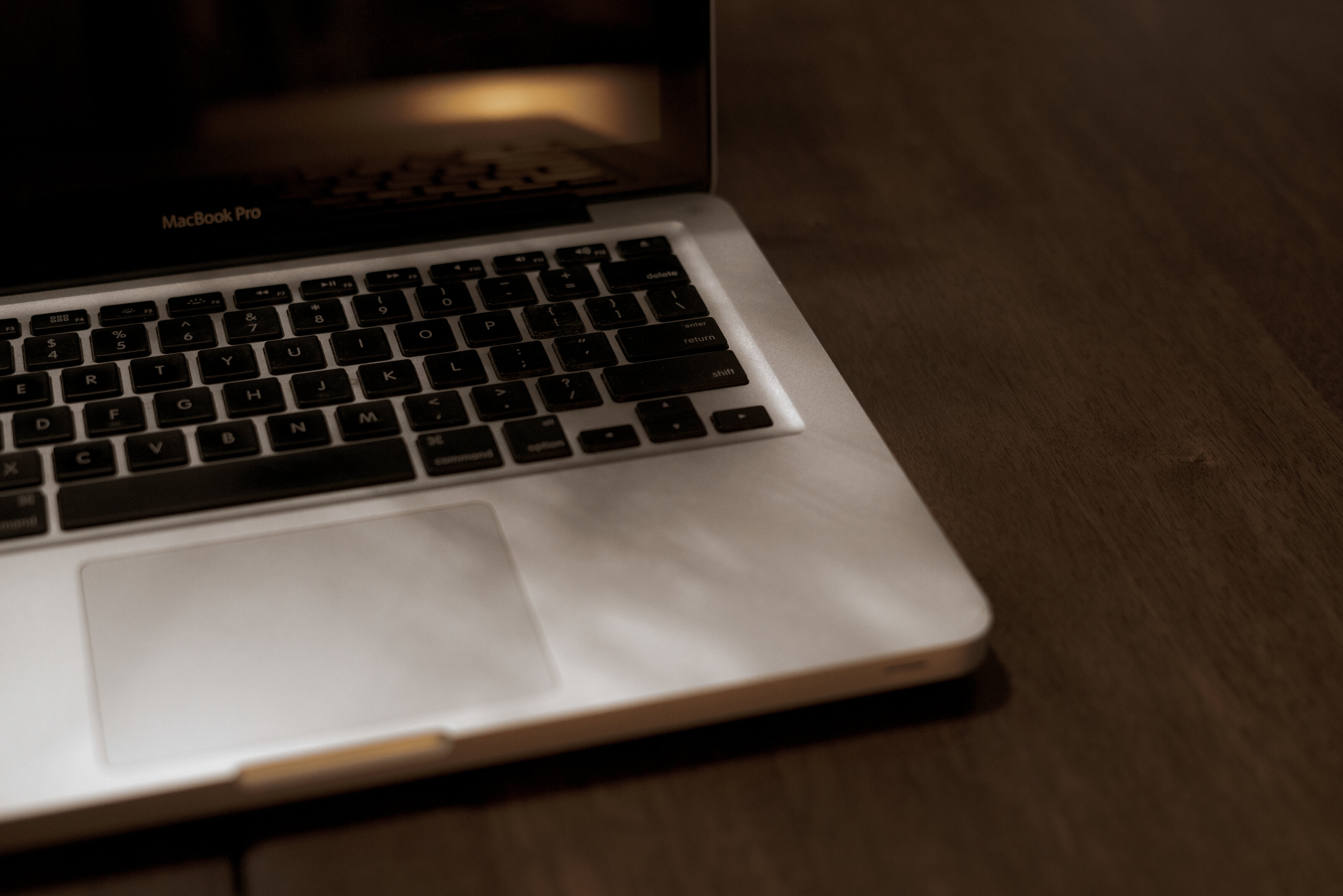 close up of laptop sitting on wooden counter