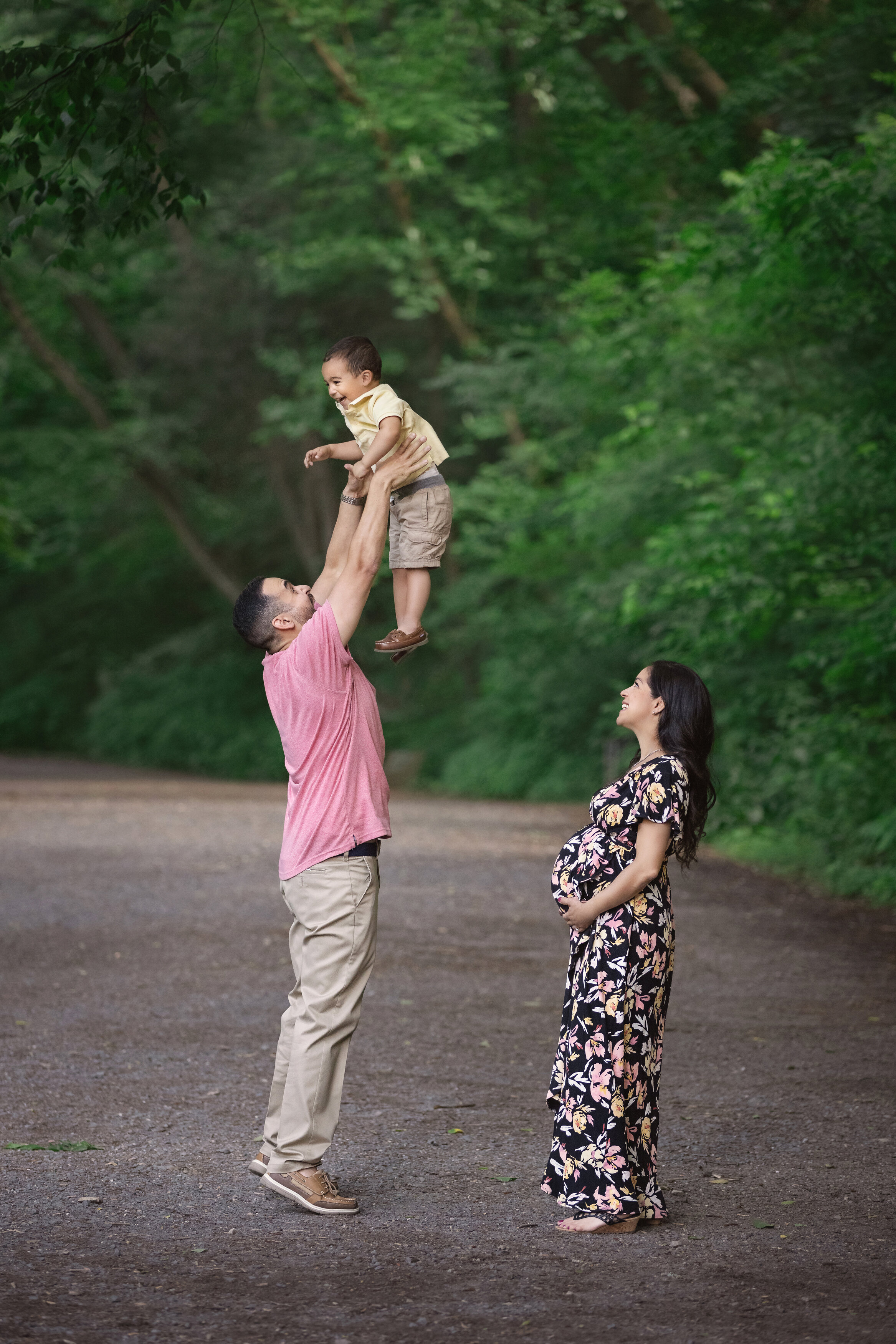 Parents throw child in the air for photos , taken by the best maternity  photographer in NJ.