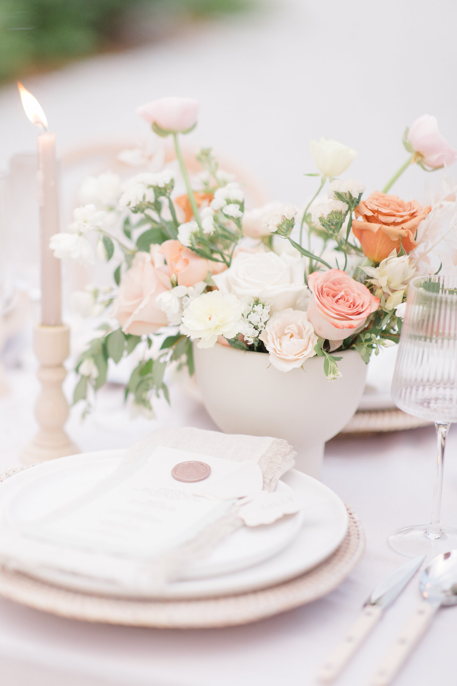 Blush and peach wedding reception table with cream linens