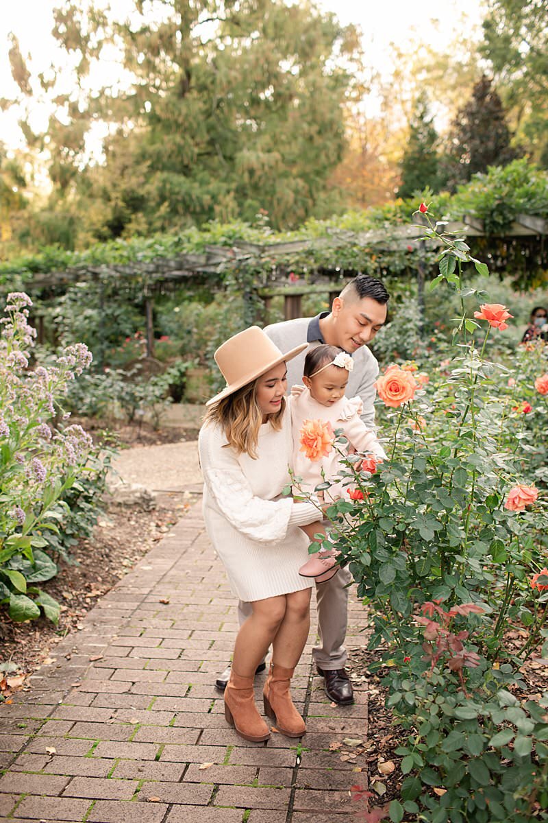 Family of 3 smelling roses by Maryland Family Photographer